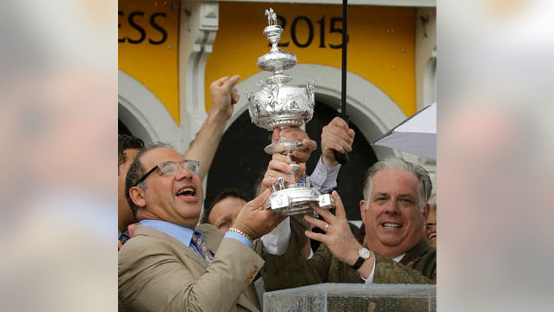 May 16, 2015: American Pharoah owner Ahmed Zayat, left, and Maryland Gov. Larry Hogan hold the Woodlawn Vase after American Pharoah with Victor Espinoza aboard won the 140th Preakness Stakes horse race at Pimlico Race Course in Baltimore. (AP Photo/Matt Slocum, File)