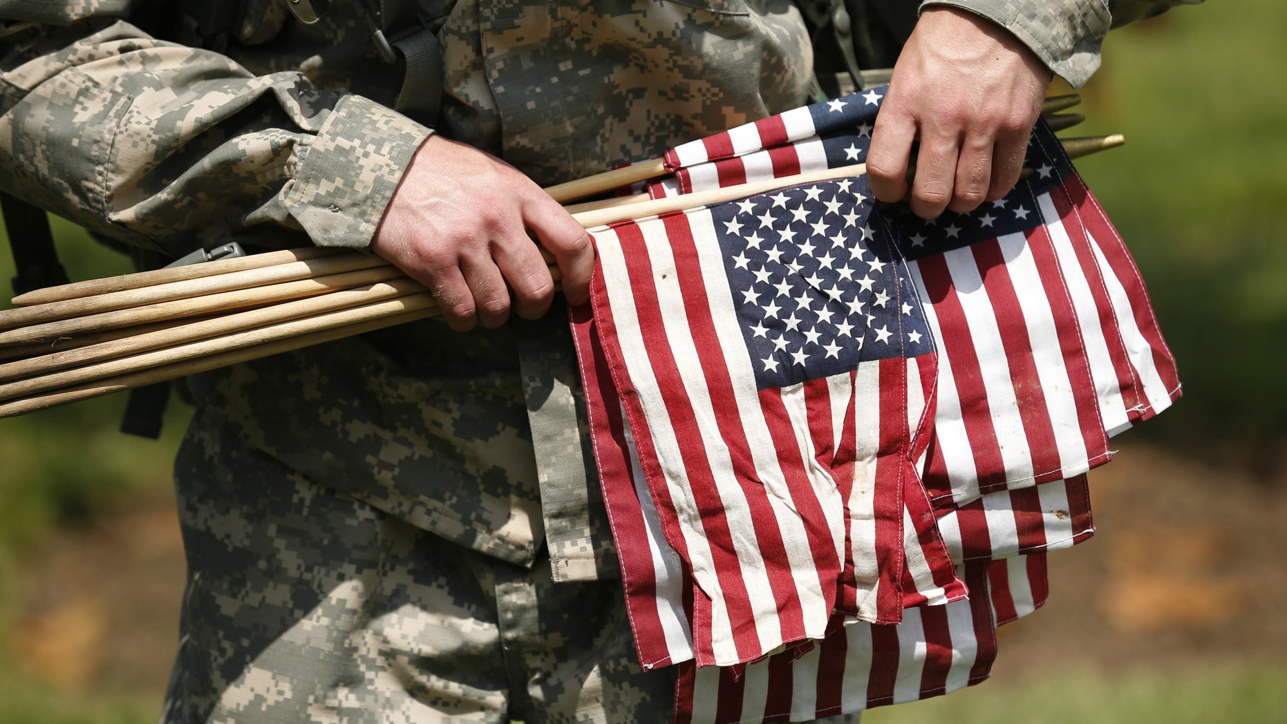 A member of the Third U.S. Infantry Regiment (The Old Guard) carries flags during a "Flags-In" ceremony at Arlington National Cemetery in Washington.