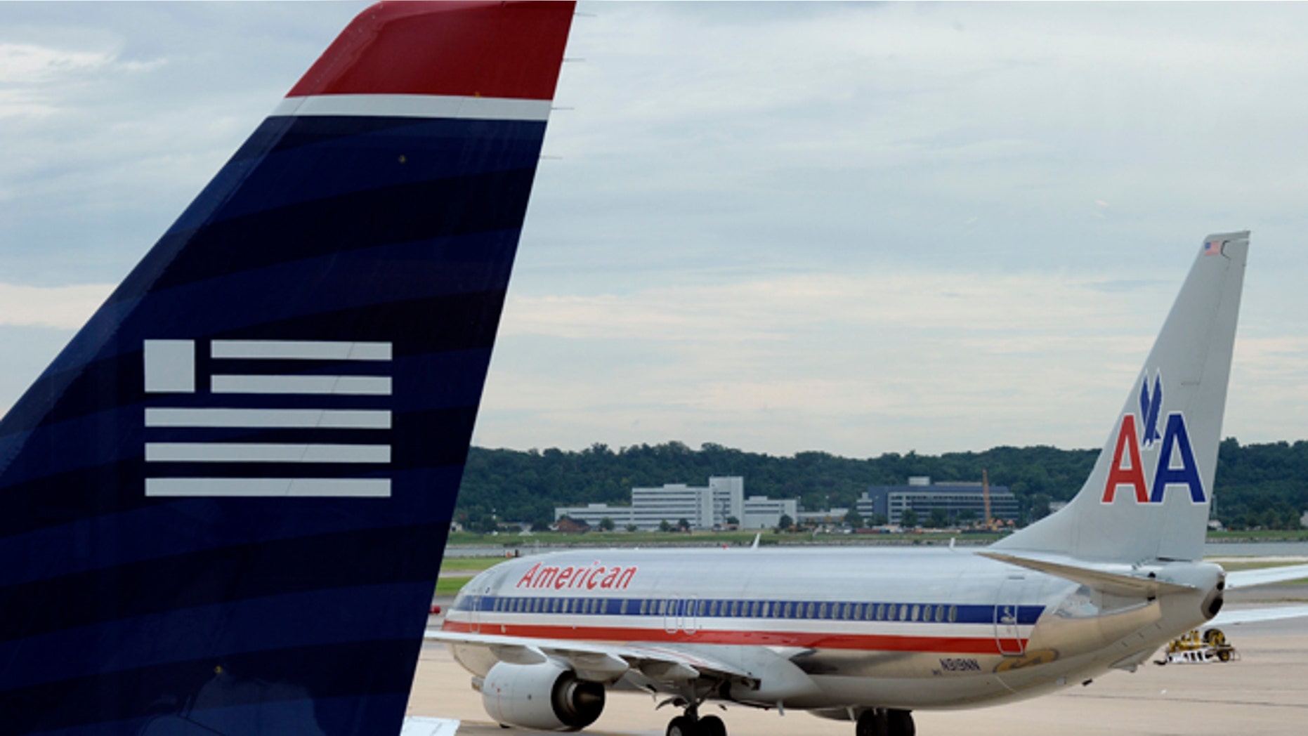 FILE: Aug. 13, 2013: An American Airlines and US Airways planes parked at Ronald Reagan National Airport in Arlington, Va.