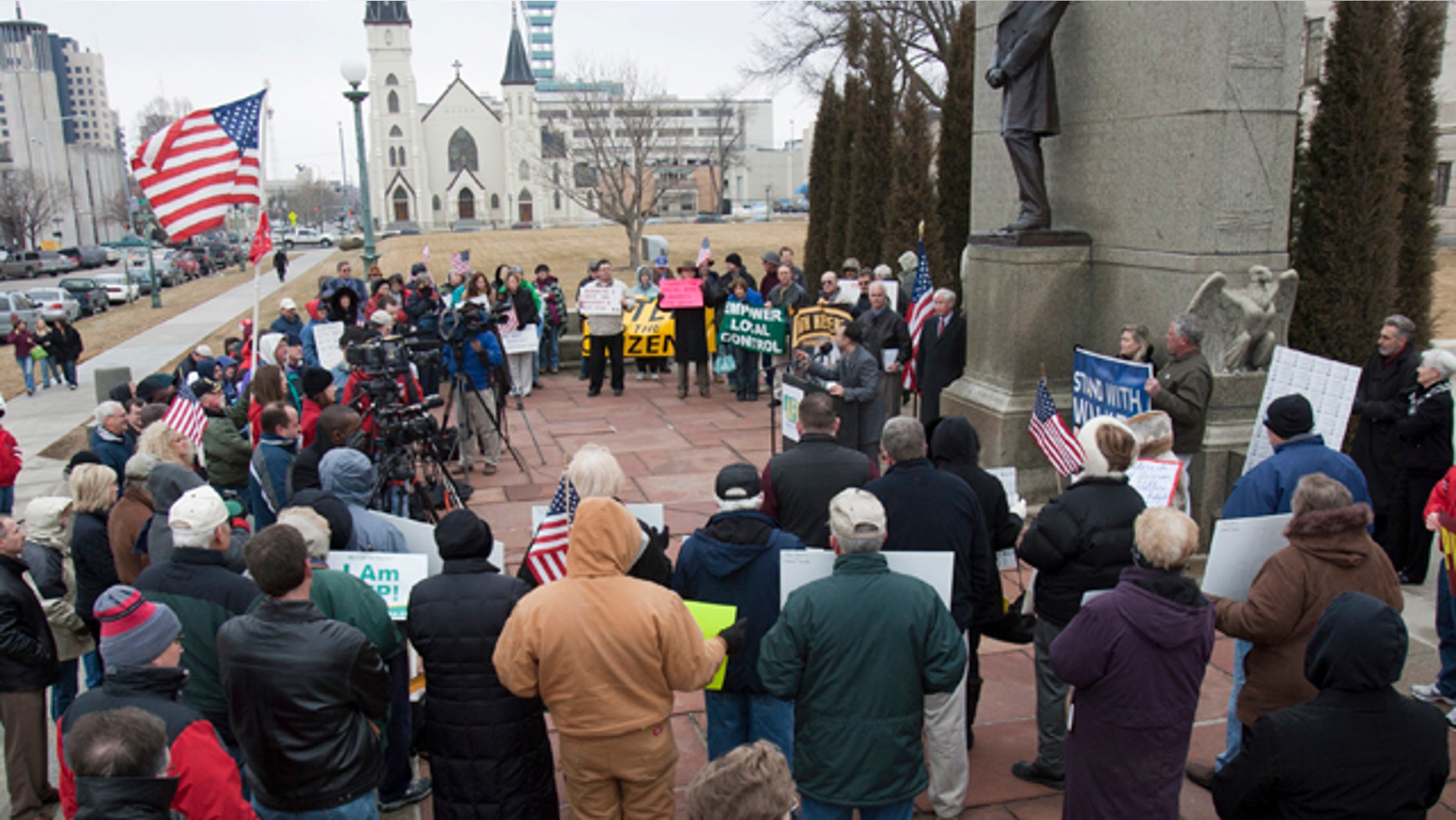Participants in a rally sponsored by Americans for Prosperity gather under a statue of Abraham Lincoln, outside the Nebraska State Capitol in Lincoln, Neb., Friday, March 4, 2011