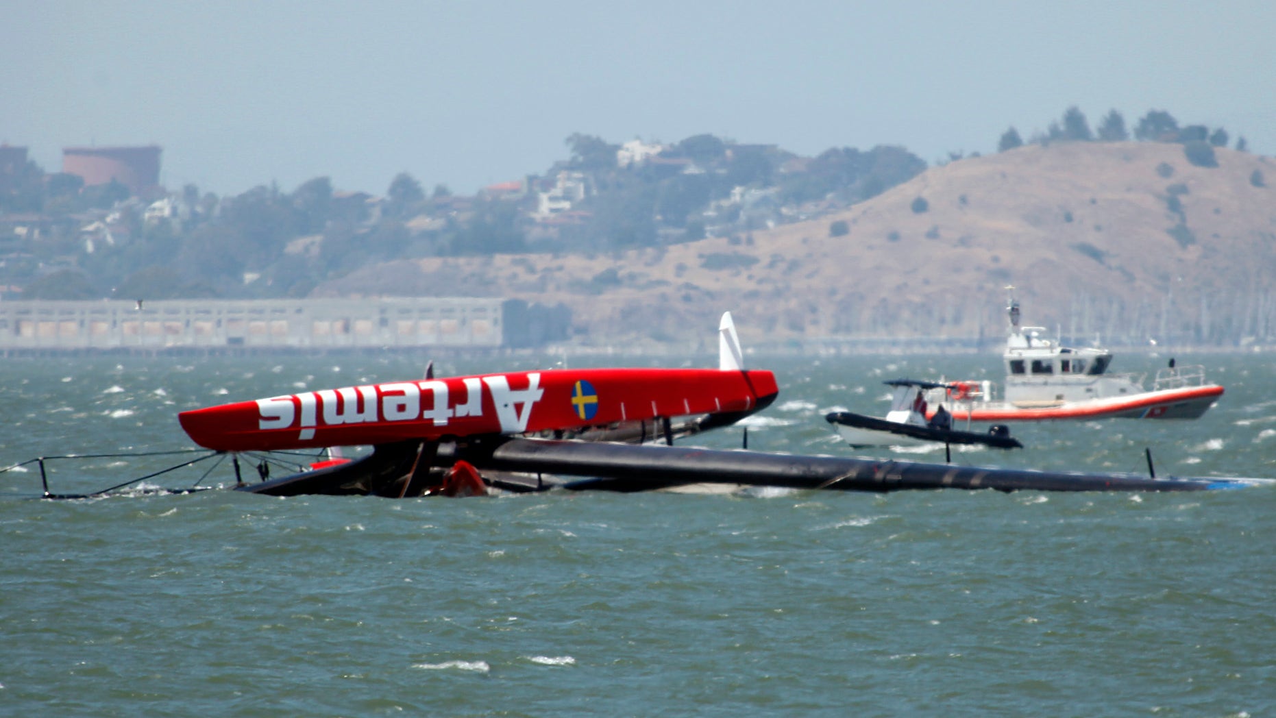 May 9, 2013: The overturned Artemis Racing AC72 catamaran, an America's Cup entry from Sweden, is towed past Treasure Island after the boat capsized during training in San Francisco Bay in San Francisco, Calif.