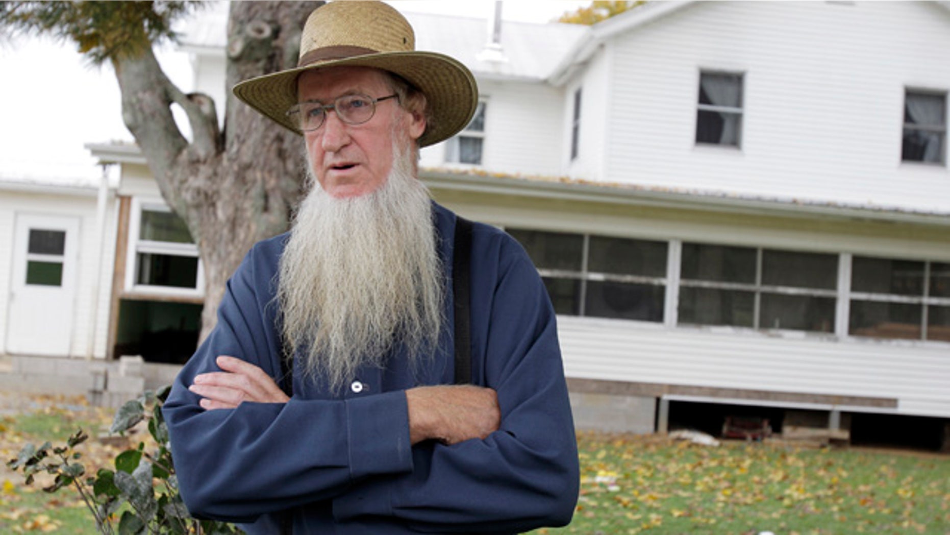 FILE - In this Monday, Oct. 10, 2011 file photo, Sam Mullet stands in front of his Bergholz, Ohio, home. An appeals court on Wednesday, Aug. 27, 2014 overturned the hate-crime convictions of 16 Amish in beard- and hair-cutting attacks on fellow members of their faith in Ohio. The attacks were in apparent retaliation against Amish who had defied or denounced the authoritarian style of leader Mullet. (AP Photo/Amy Sancetta, File)