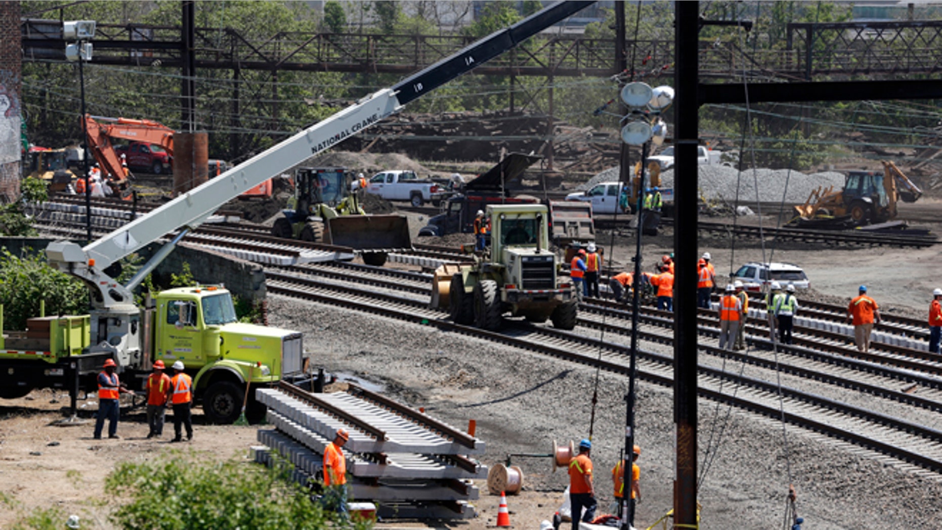 Workers labor on the site where a deadly train derailment occurred earlier in the week, Friday, May 15, 2015, in Philadelphia. Amtrak is working to restore Northeast Corridor rail service between New York City and Philadelphia. Service was suspended after a train derailed in Philadelphia on Tuesday night, killing eight passengers and injuring more than 200. (AP Photo/Julio Cortez)