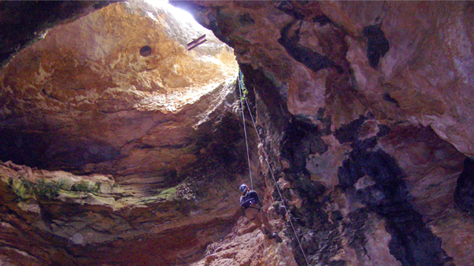 In an image provided by the Bureau of Land Management, cave specialist Bryan McKenzie rappels into Natural Trap Cave in north-central Wyoming during a cleanup expedition. The cave holds the remains of tens of thousands of animals, including many now-extinct species, from the late Pleistocene period tens of thousands of years ago. Starting July 28, 2014, scientists plan to venture back into the cave and resume digging for the first time in more than 30 years. (AP Photo/Bureau of Land Management)