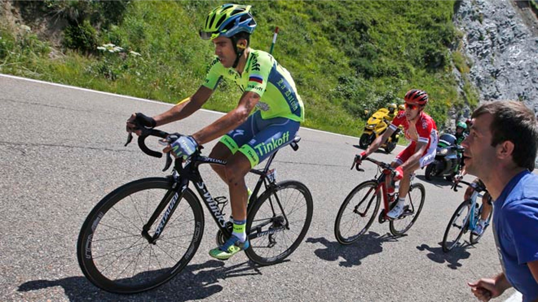 Spain's Alberto Contador, left, strains as he rides in the back of the pack with Franceâs Nicolas Edet, right, during the ninth stage of the Tour de France cycling race over 184.5 kilometers (114.3 miles) with start in Vielha Val d'Aran, Spain, and finish in Andorra Arcalis, Andorra, Sunday, July 10, 2016. (AP Photo/Christophe Ena)