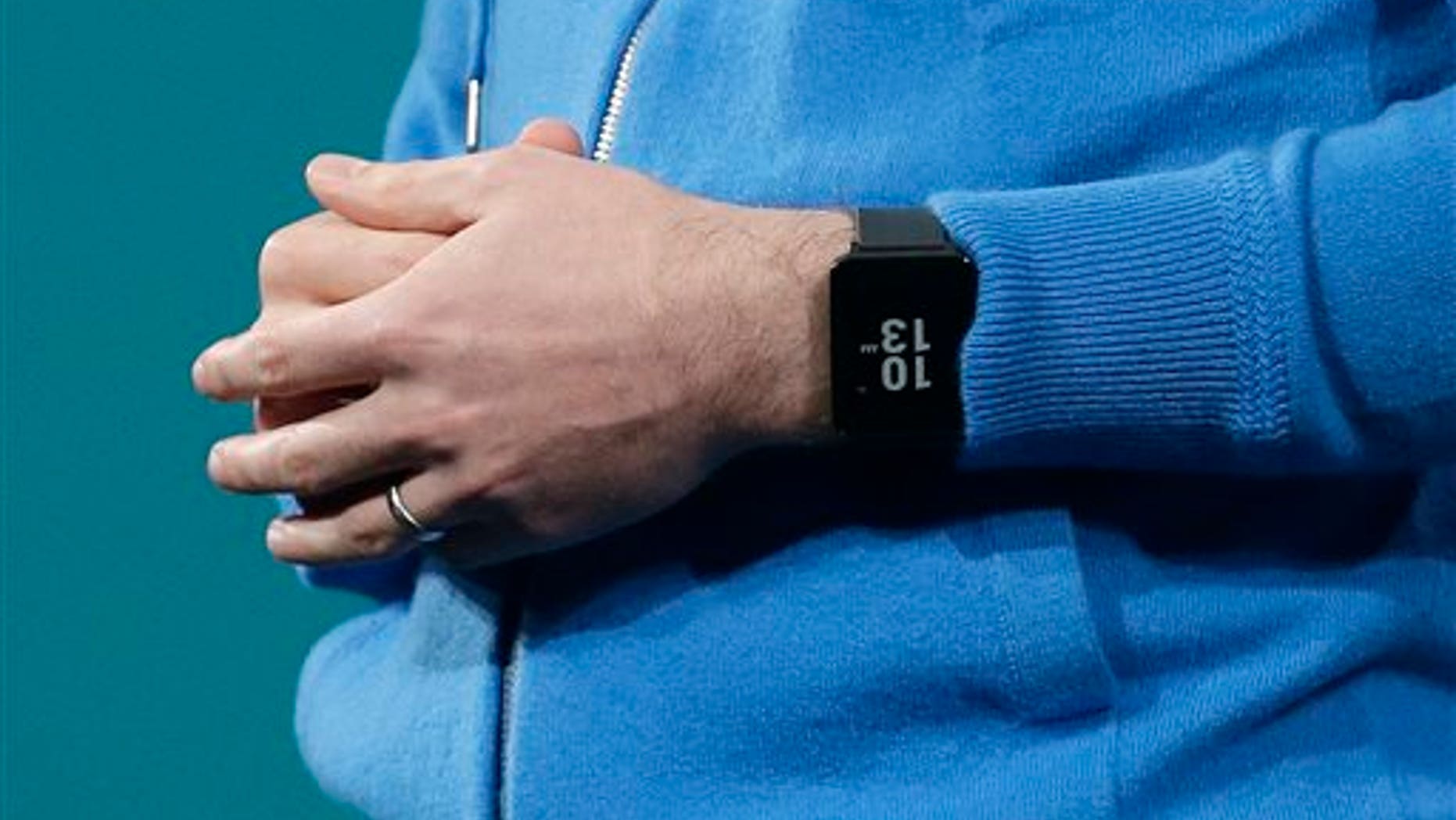 David Singleton, Android director of engineering, wears an Android Wear watch on his wrist while speaking at the Google I/O 2014 keynote presentation in San Francisco, Wednesday, June 25, 2014. As the Internet giant's Android operating system stretches into cars, homes and smartwatches, this year's annual confab will expand on its usual focus on smartphones and tablets. (AP Photo/Jeff Chiu)