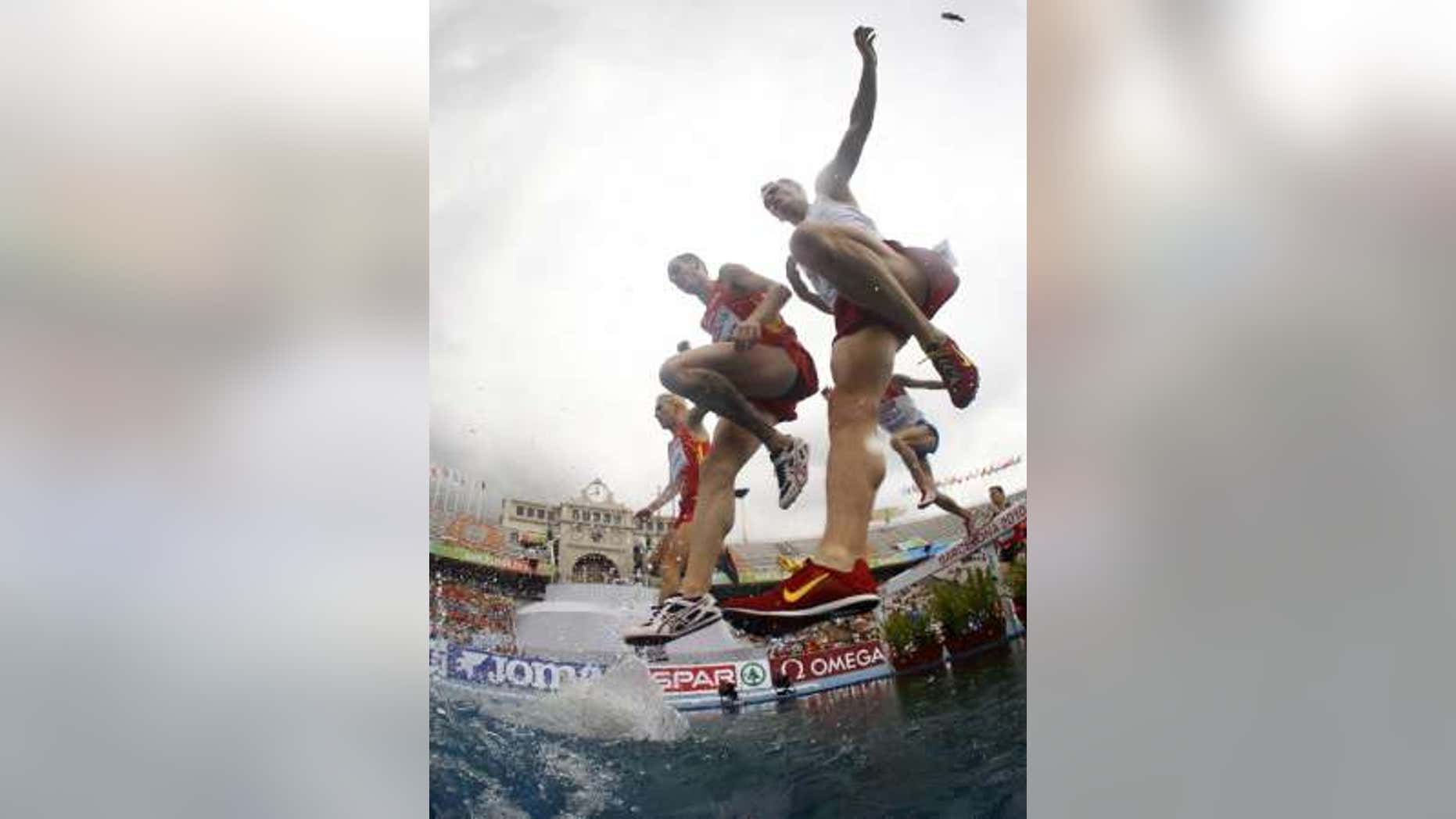 July 30, 2010: Angel Mullera of Spain and Hubert Pokrop of Poland jump a water obstacle in the men's 3000 metres steeplechase heats at the European Athletics Championships in Barcelona.
