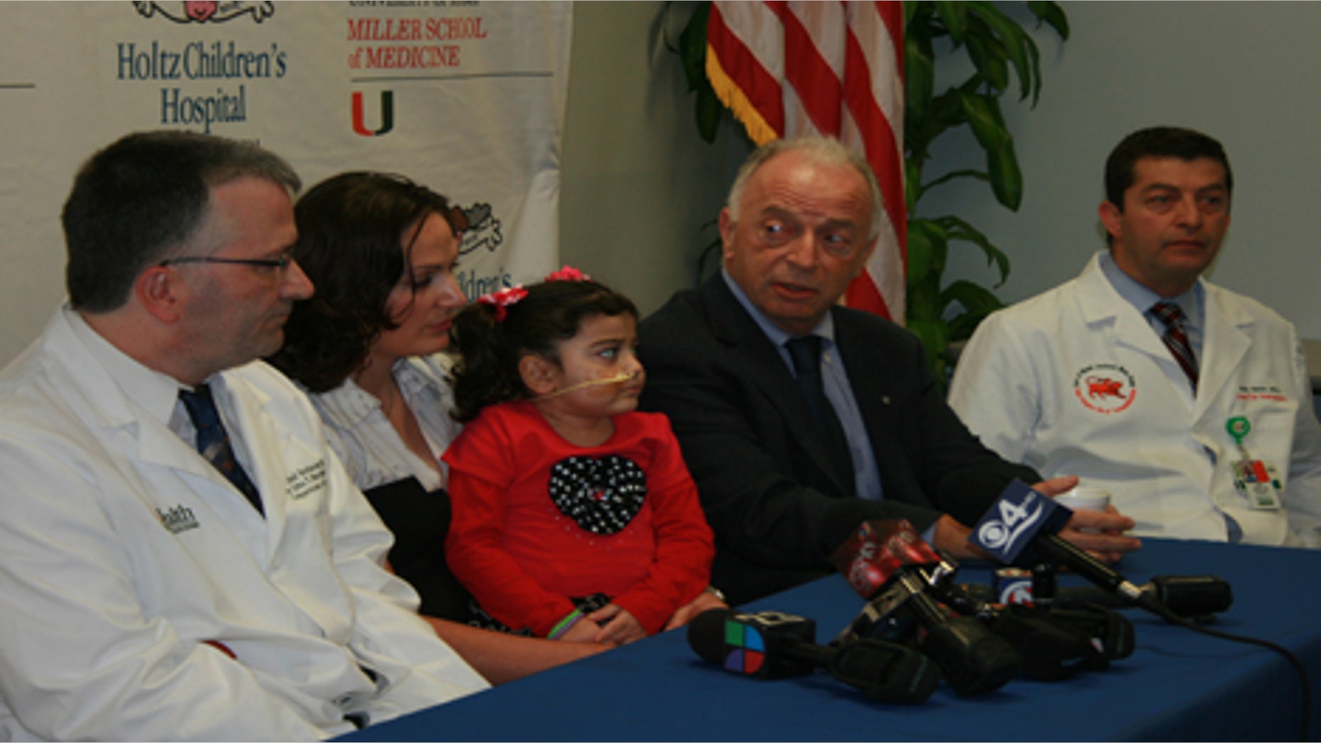 Angela Bushi sits with her mother, along with her surgeon Dr. Andreas Tzakis and the geneticist who diagnosed her, Dr. Olaf Bodamer, as they announce the success of their groundbreaking surgery.