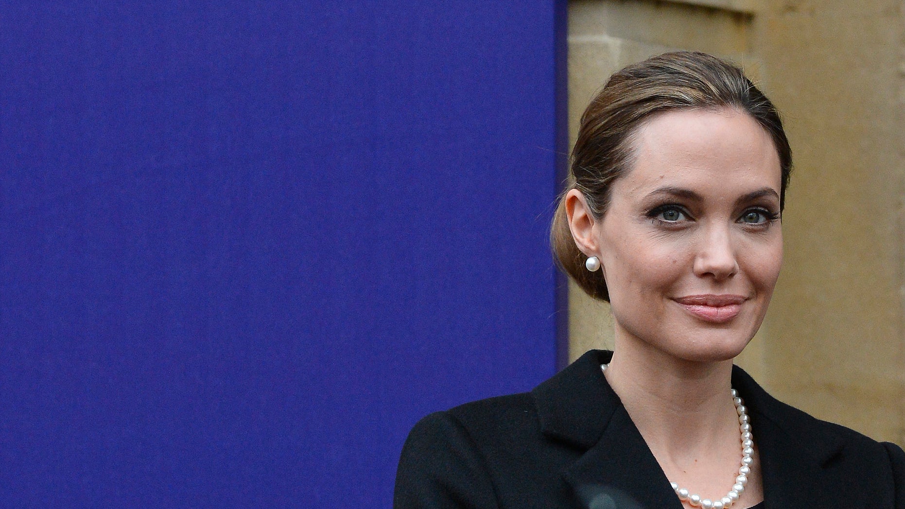 Actress Angelina Jolie poses for a photograph as she arrives for the G8 Foreign Ministers Meeting in central London.