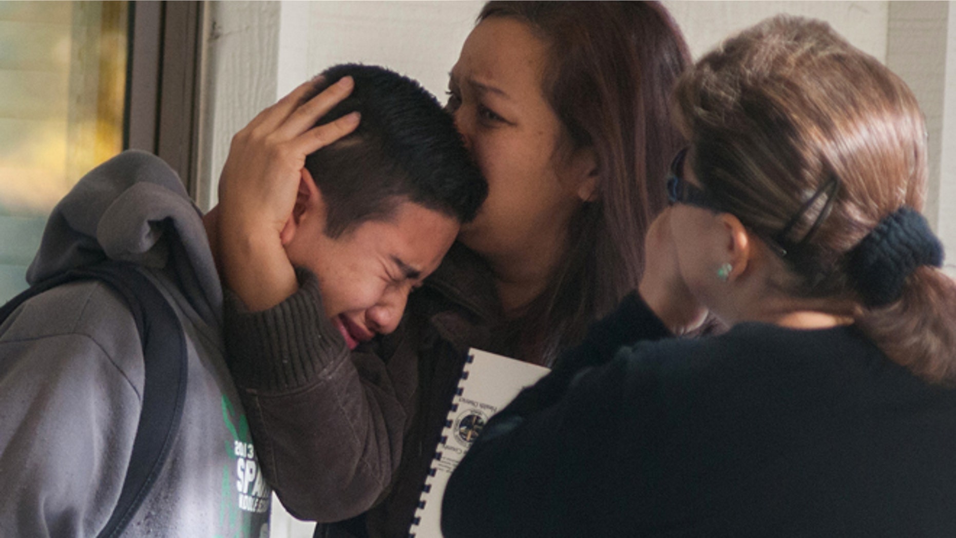 A Sparks Middle School student cries and is comforted after being released from Agnes Risley Elementary School, where some students were evacuated to after a shooting at SMS in Sparks, Nev. on Monday, October 21, 2013 in Sparks, Nev. A middle school student opened fire on campus just before the starting bell Monday, wounding two boys and killing a staff member who was trying to protect other children, Sparks police said Monday. The lone suspected gunman was also dead, though it's unclear whether the student committed suicide. (AP Photo/Kevin Clifford)