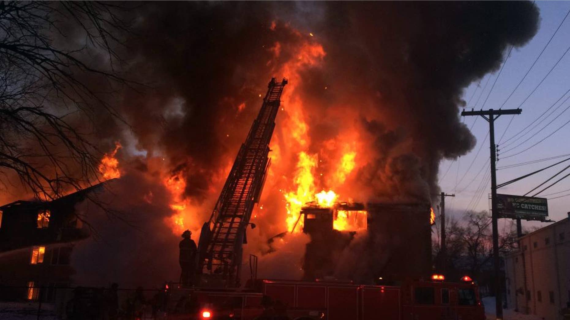 Firefighters battle a four-alarm fire at a three-story apartment complex Wednesday morning, March 5, 2014 on Detroit's west side. An official says the fire forced some people to jump to escape. (AP Photo/Detroit Free Press, Robert Allen) DETROIT NEWS OUT; NO SALES
