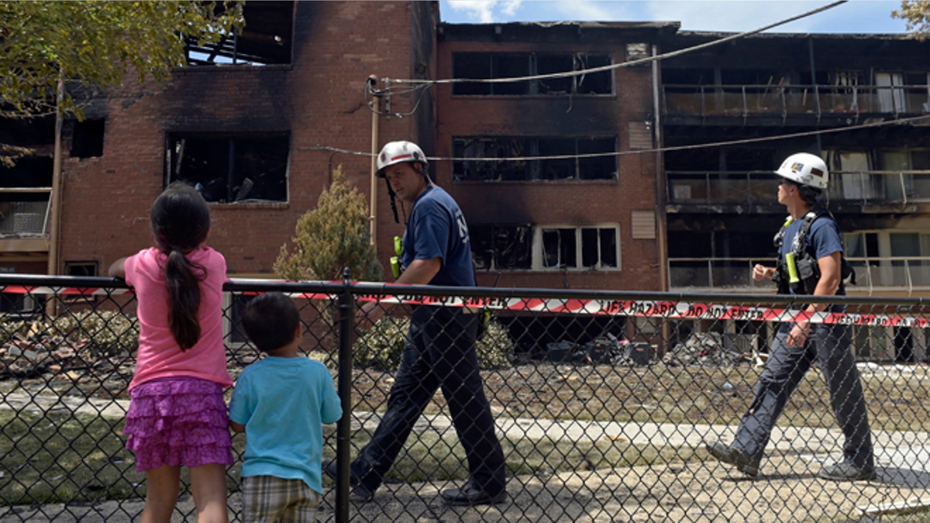 People view the scene of an apartment building fire in Silver Spring, Md., Thursday, Aug. 11, 2016.