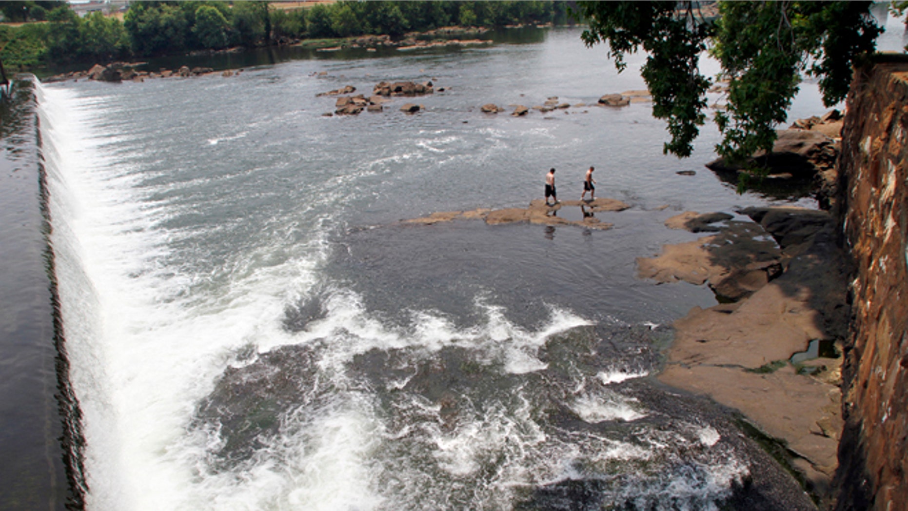 June 11, 2011: Men walk on the rocks in the Chattahoochee River below the City Mills dam near Columbus, Ga.