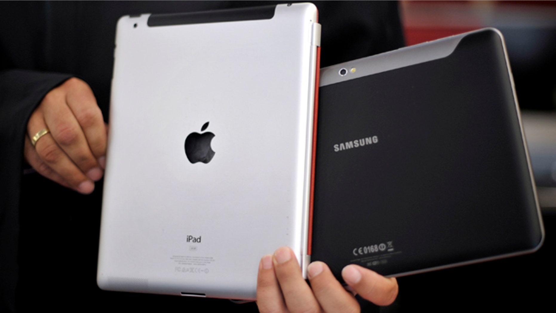 Aug. 25, 2011: An attorney holds an Apple iPad, left, and a Samsung Galaxy Tab 10.1 at the regional court in Duesseldorf, Germany.