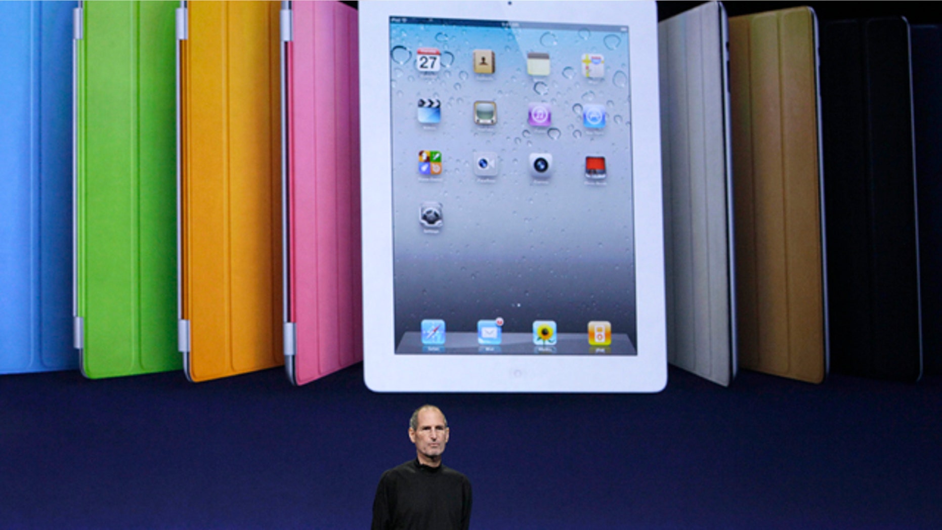 Apple chairman and CEO Steve Jobs stands under an image of the iPad 2 at an Apple event at the Yerba Buena Center for the Arts Theater in San Francisco, Wednesday, March 2, 2011.