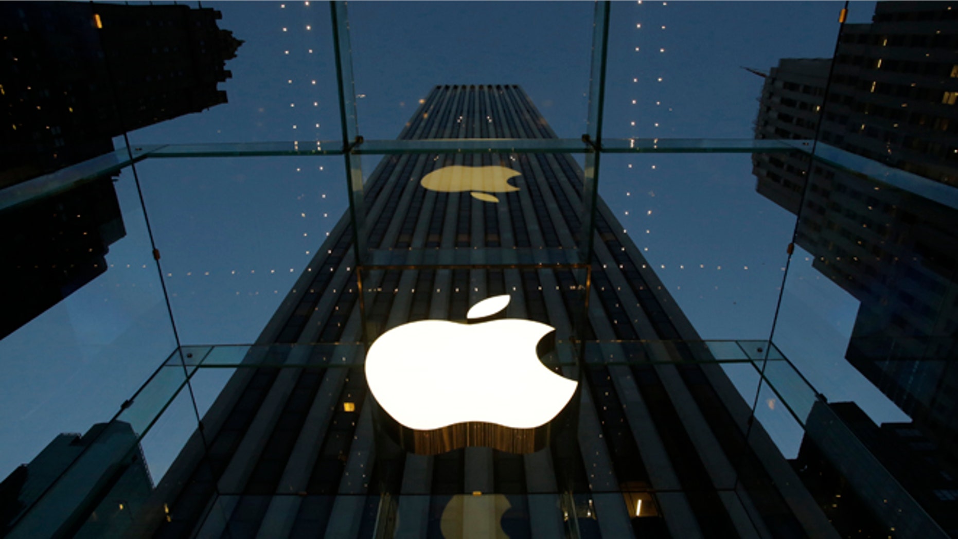 The Apple logo is illuminated in the entrance to the Fifth Avenue Apple store, in New York.