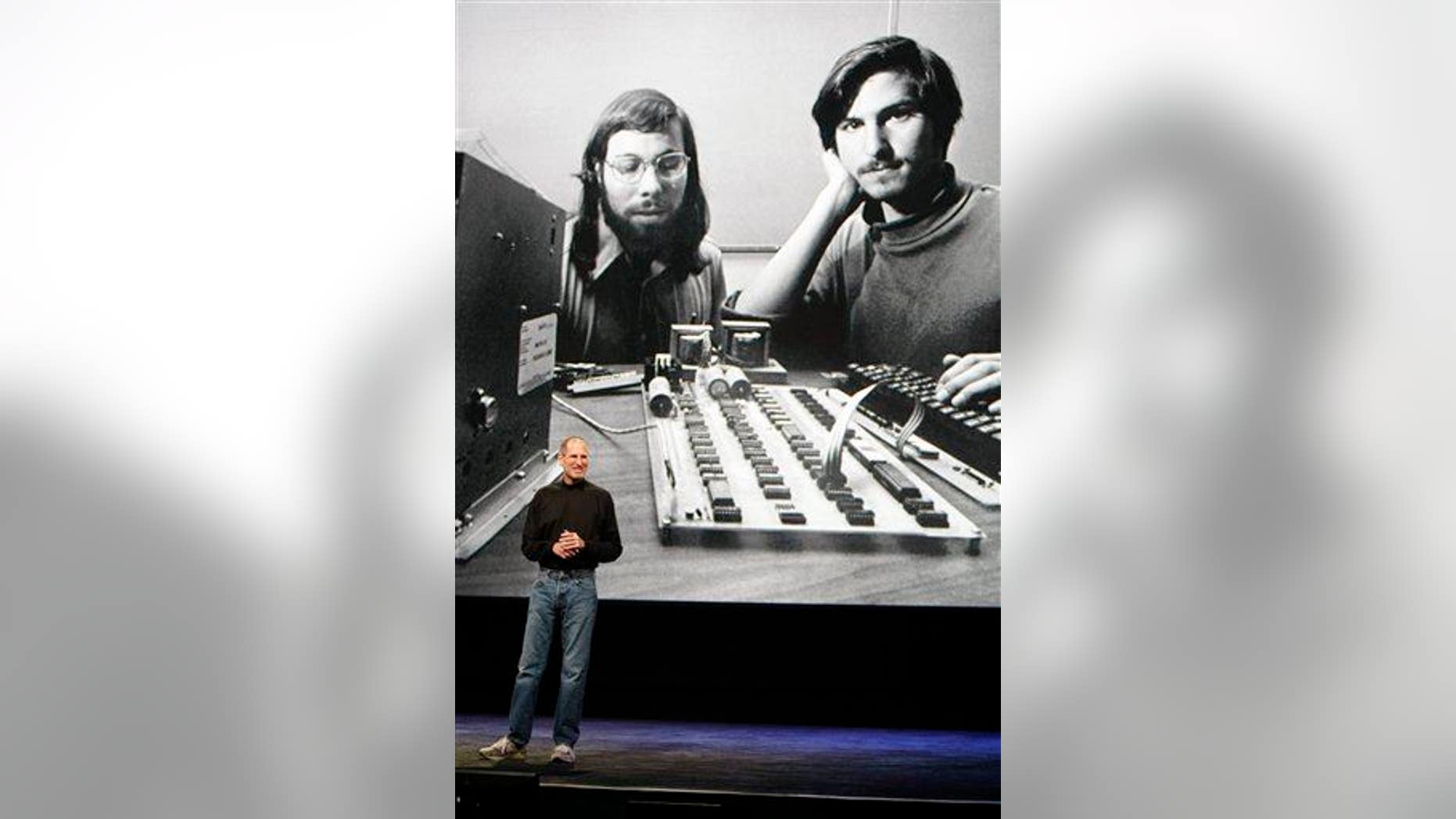 In this 2010 image, Steve Jobs stands in front of an old photo of himself and Steve Wozniak.