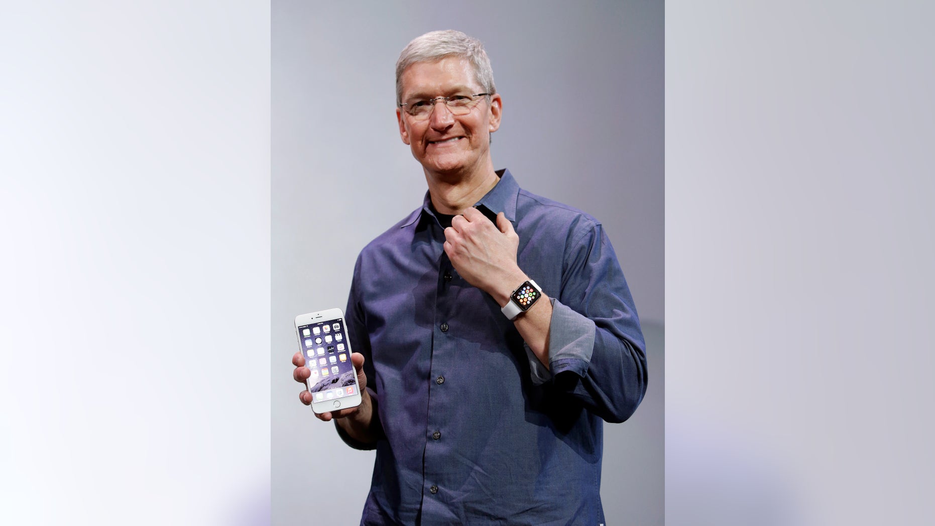 Apple CEO Tim Cook, holding an iPhone 6 Plus, discusses the new Apple Watch and iPhone 6s on Tuesday, Sept. 9, 2014.