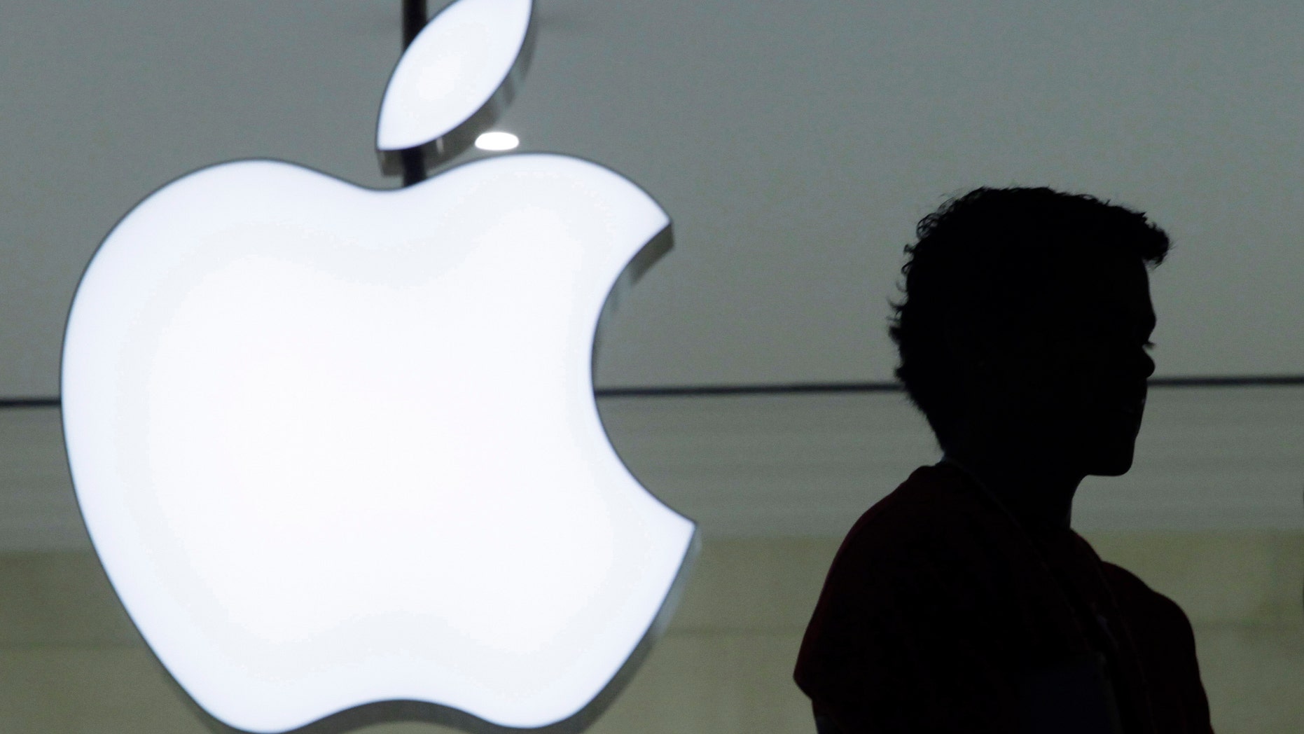 FILE - In a Wednesday, Dec. 7, 2011, file photo, a person stands near the Apple logo at the company's store in Grand Central Terminal, in New York. Apple will show off its newest products Sept. 9, 2014. The iPhone and iPad maker set the date in invitations mailed Thursday, Aug. 28, 2014, to reporters and others who typically come to see the unveiling of Apple's latest twists on technology. (AP Photo/Mark Lennihan, File)