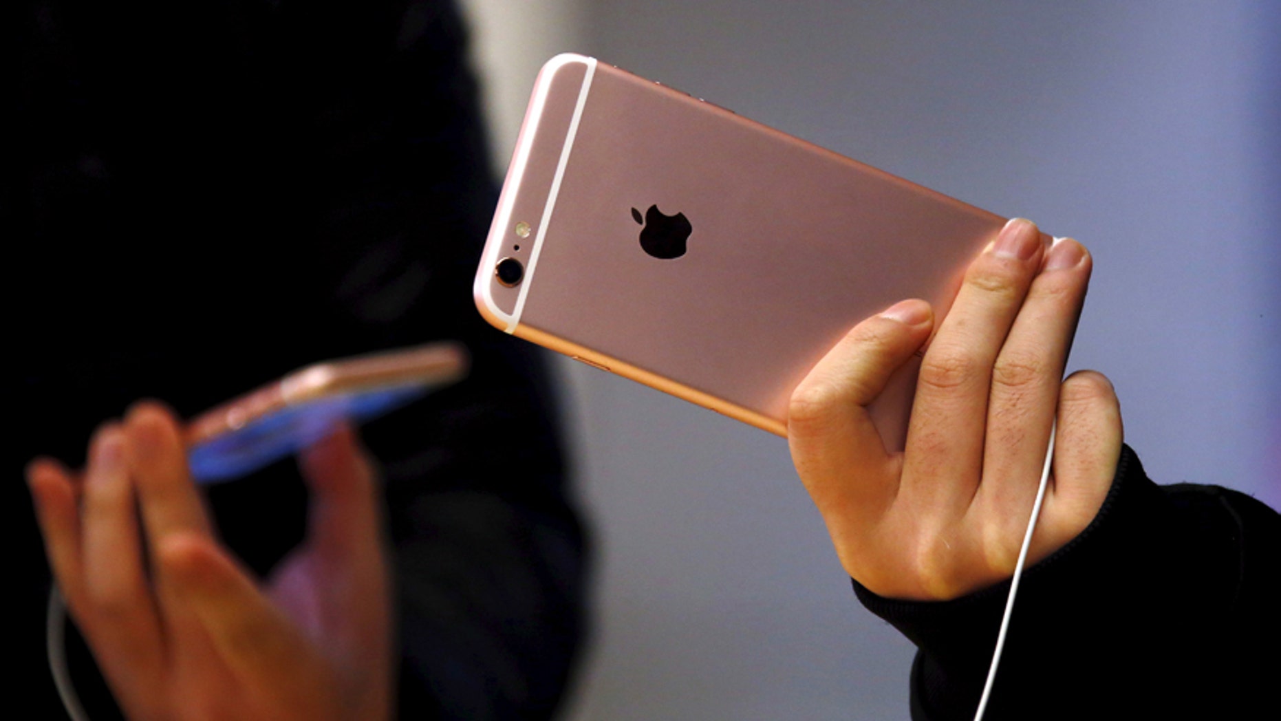 File photo - Customers hold the iPhone 6s during the official launch at the Apple store in central Sydney, Australia, Sept. 25, 2015.