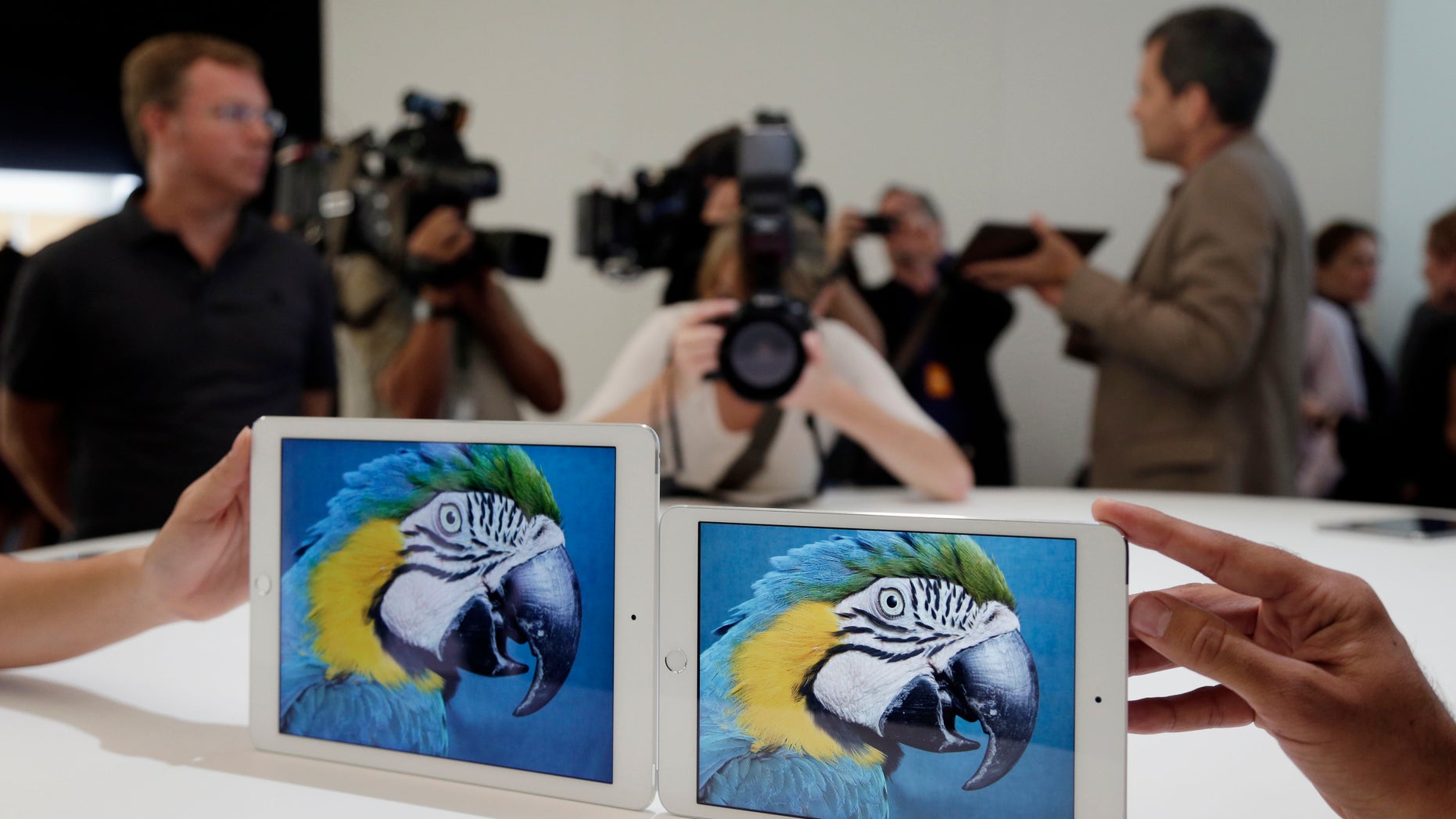 The iPad Air 2, left, and iPad Mini 3 are shown side to side at Apple headquarters in Cupertino, Calif.