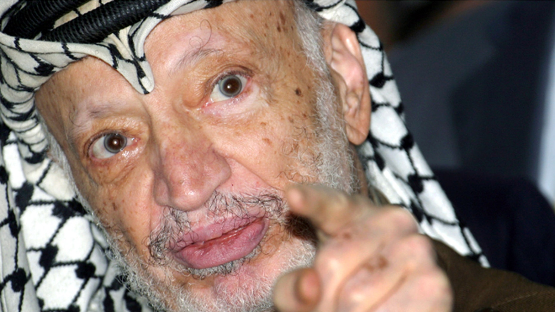 Sept. 4, 2004: Palestinian President Yasser Arafat talks to the media after opening a voter registration drive at a polling station at his headquarters in the West Bank city of Ramallah.