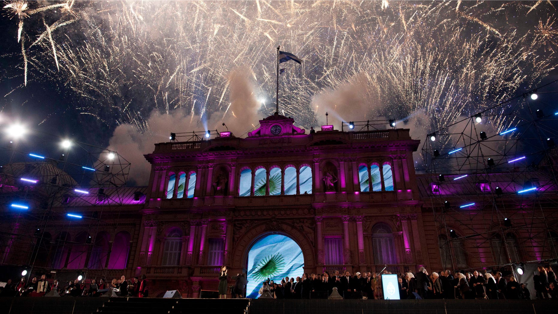 The government house is bathed in purple light as fireworks explode over a government rally in Buenos Aires, Argentina, Saturday, May 25, 2013. Cristina Fernandez's government and supporters are celebrating 10 years since she and her late husband Nestor Kirchner have held office, and the 203th anniversary of Argentina's May Revolution. (AP Photo/Natacha Pisarenko)