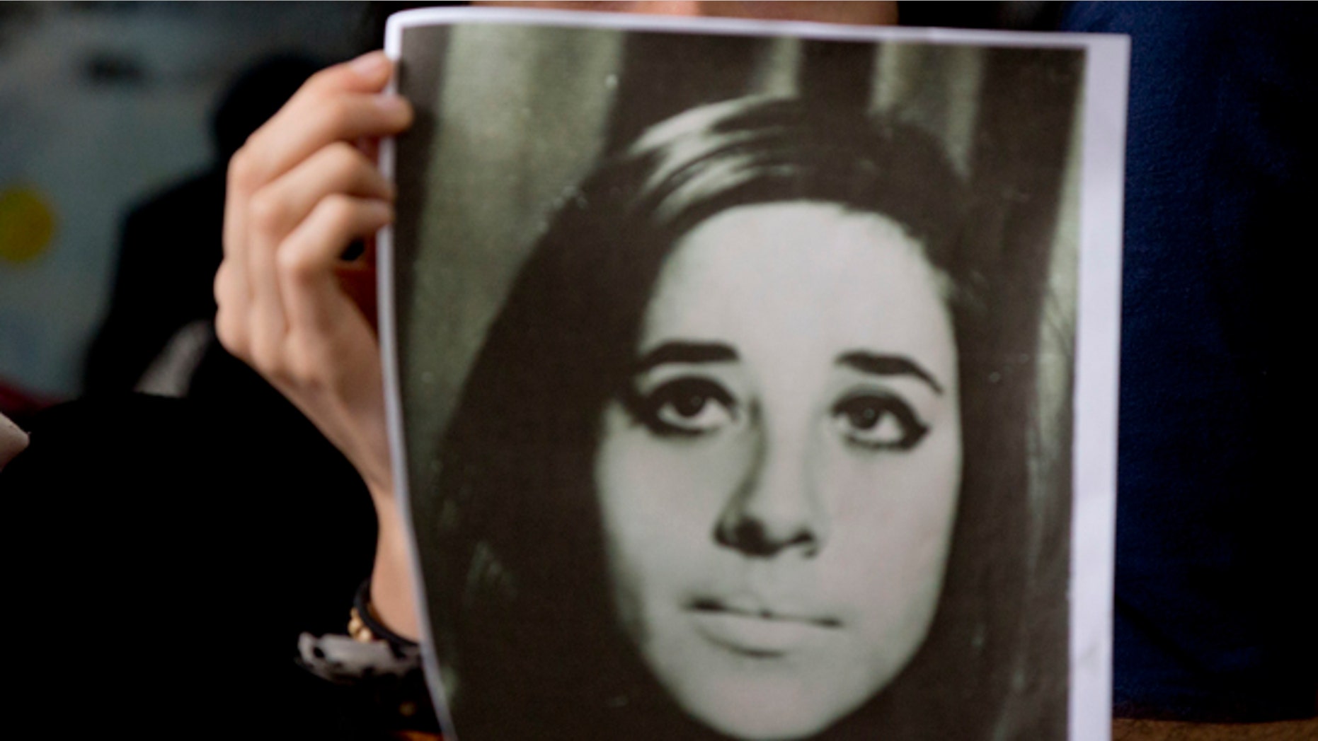 A woman holds an image of disappeared Ana Maria Lanzillotto during a press conference in Buenos Aires on Oct. 5, 2016.