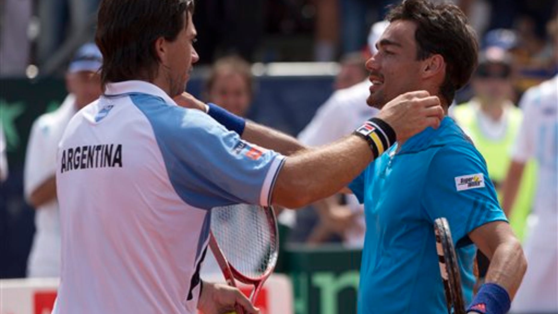 Argentina's Carlos Berlocq, left, and Italy's Fabio Fognini embrace at the end of their Davis Cup singles match, in Mar del Plata, Argentina, Sunday, Feb. 2, 2014. Fognini defeated Berlocq 7-6, 4-6, 6-1, 6-4 to give Italy a 3-1 victory. (AP Photo/Eduardo Di Baia)