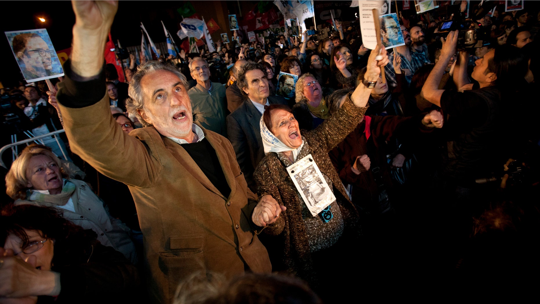 Human right activists, among them Mothers of Plaza de Mayo member Tati Almeida, second from left, celebrate after a trial against former military and police officials in Buenos Aires, Argentina, Wednesday, Oct. 26, 2011. A court in Argentina has sentenced 12 former military and police officials to life in prison for crimes against humanity committed during the country's 1976-1983 dictatorship. The men were convicted of kidnapping, torturing and killing leftist dissidents at a torture center called the Navy Mechanics School. (AP Photo/Victor R. Caivano)