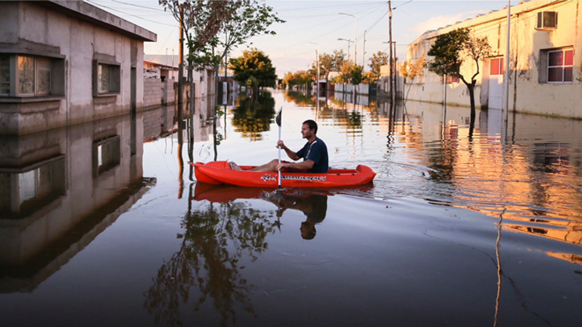 A man rows a dinghy through flood waters in Idiazabal, Argentina, Thursday, March 5, 2015. Flooding throughout four Argentine provinces have forced thousands of people to flee their homes. In the small town of Idiazabal, in the Cordoba province, residents continue to wade through fully submerged streets that have been under water for over one week. While rains stopped on Thursday and are not expected to return over the coming days, floodwaters have not subsided. (AP Photo/Nico Aguilera)