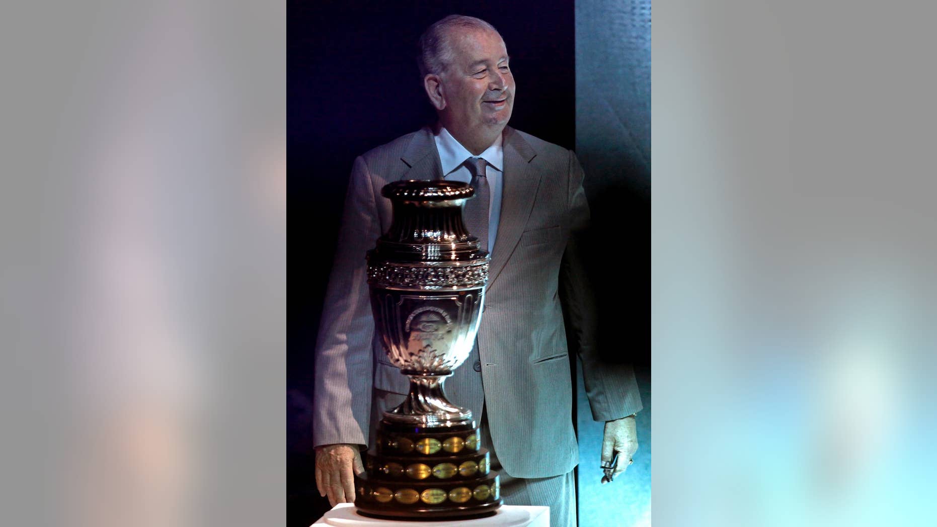 FILE - In this Nov. 11, 2010 file photo, Julio Grondona, president of the Argentine Football Association, stands behind the Copa America trophy during the draw of the groups' ceremony in La Plata, Argentina. Grondona was hospitalized on Wednesday, July 30, 2014, said national football authorities, who said he was "not feeing well." (AP Photo/Natacha Pisarenko, File)
