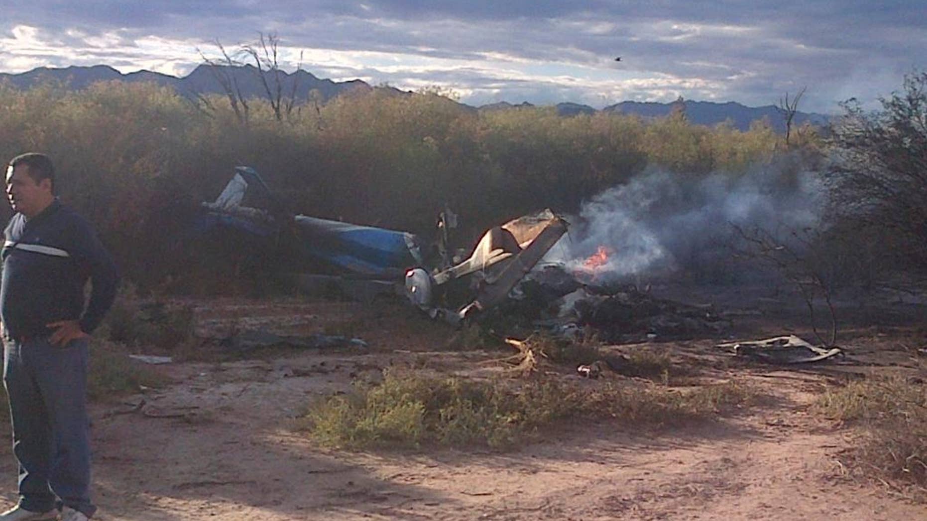 A man stands near one of two helicopters that crashed near Villa Castelli in the La Rioja province of Argentina, Monday, March 9, 2015. Two helicopters with passengers who were filming a documentary crashed Monday in the remote area of northwest Argentina, killing all 10 people on board both aircrafts, authorities said. (AP Photo/Jose Alamo)