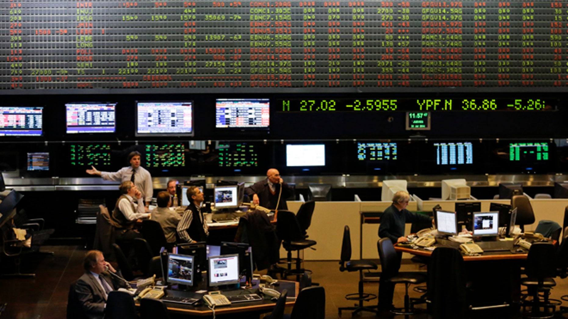 FILE - In this July 31, 2014 file photo, brokers work at the Buenos Aires Stock Exchange in Buenos Aires, Argentina. Latin America and the Caribbean will post an economic contraction in 2016, the International Monetary Fund forecast in a report issued Wednesday, April 27, 2016, capping the regionâs worst two-year period since the 1982 debt crisis. But the IMF said the region is expected to rebound in 2017. (AP Photo/Victor R. Caivano, File)