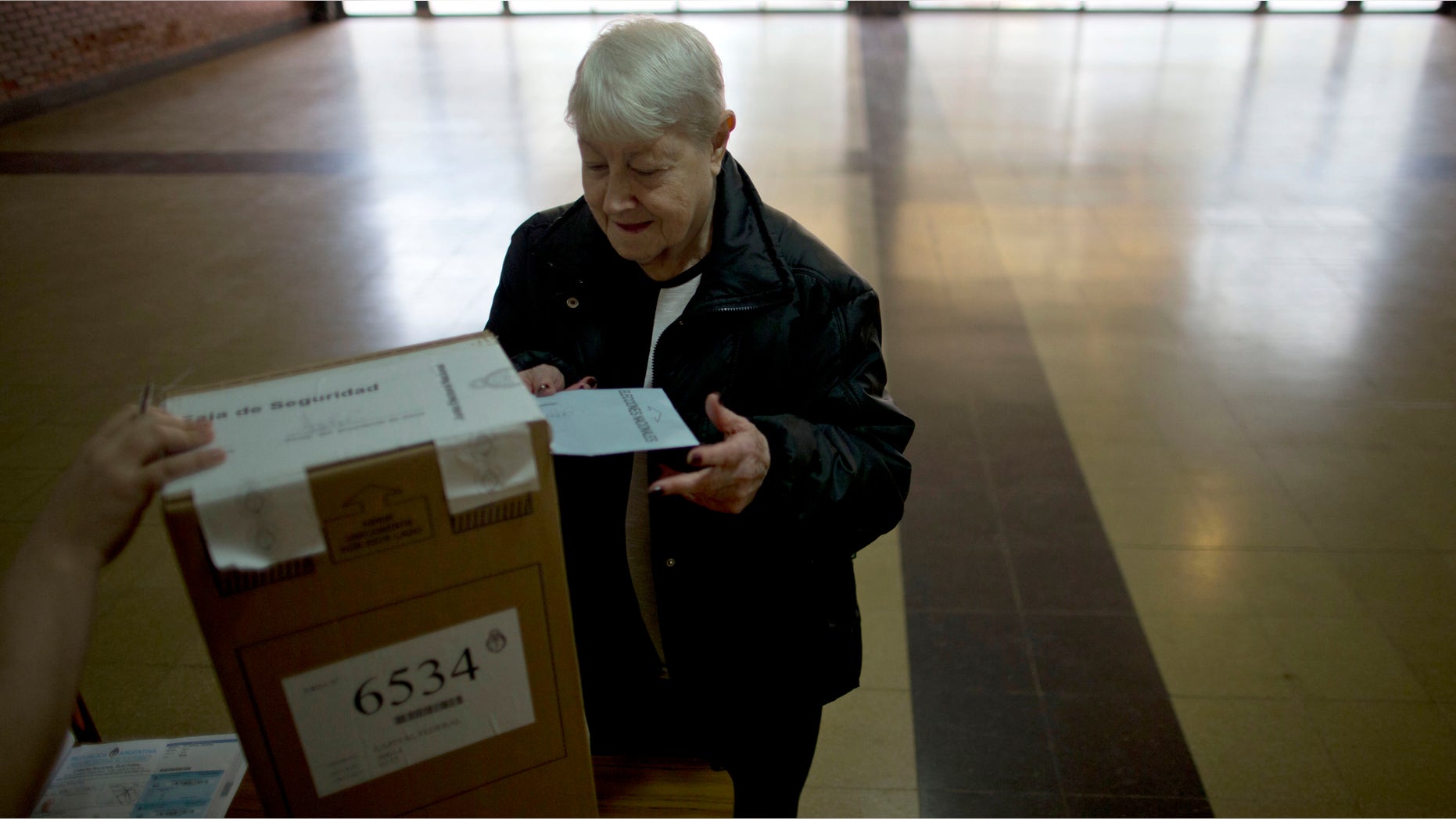 A woman casts her vote during open primary elections for presidential candidates in Buenos Aires, Argentina, Sunday, Aug. 9, 2015. The voters will decide presidential candidates in their respective parties ahead of the Oct. 25, 2015 general elections. (AP Photo/Natacha Pisarenko)