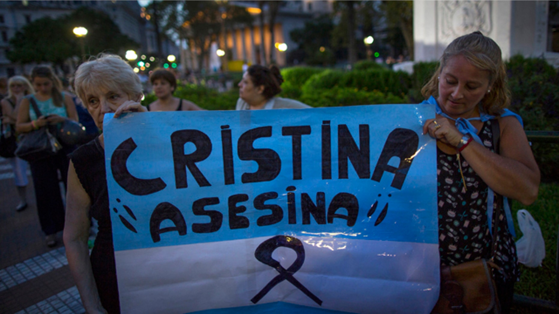 Jan. 26, 2015: Protesters hold a replica of the Argentine flag that reads in Spanish 'Cristina Assassin,' referring to President Cristina Fernandez as she delivers a live televised speech, her first public comments since the mysterious death of a prosecutor in Buenos Aires. (AP Photo/Ivan Fernandez)