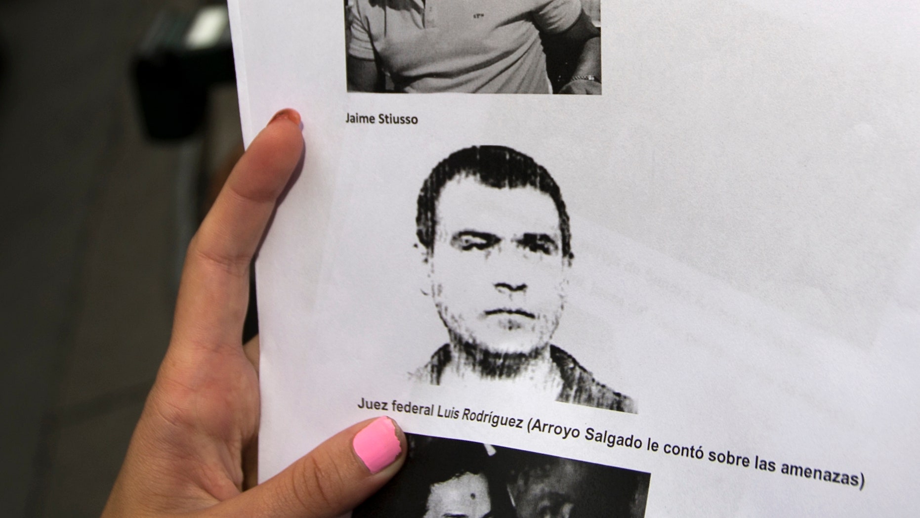 A reporter holds a picture of Antonio Stiuso, one of Argentina's most enigmatic spy chiefs.