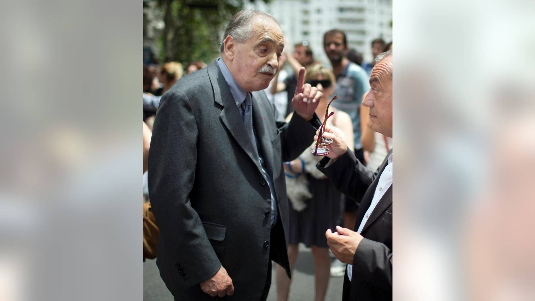 FILE - In this Jan. 11, 2015 file photo, Argentina's former judge Julio Cesar Strassera, left, speaks with France's ambassador to Argentina, Jean-Michel Casa, during a demonstration in solidarity with the victims of an attack in Paris, outside France's embassy in Buenos Aires, Argentina. Strassera, prosecutor in the trial that saw the conviction of Argentina's military dictatorship leaders, died in Buenos Aires on Friday, Feb. 27, 2015. He was 81. Strassera died in the clinic San Camilo de Buenos Aires where he had been admitted for a respiratory illness. (AP Photo/Rodrigo Abd, File)
