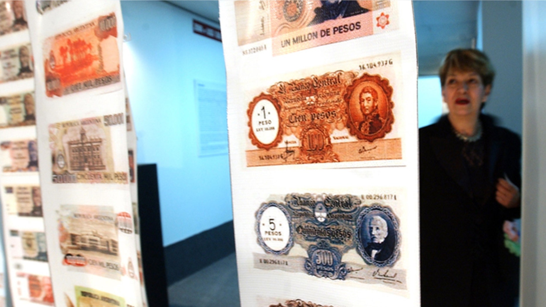 FILE - In this April, 28, 2005, file photo, a woman looks at old currency during the opening of the Foreign Debt Museum in Buenos Aires, Argentina. The museum, which is the world's first dedicated to a country's debt, opened nearly four years after Argentina staged the largest debt default in modern history. Argentine President Cristina Fernandez said Monday June 16, 2014 that Argentina can't comply with U.S. court orders to pay $1.5 billion to winners of a decade-long legal battle over defaulted debt, the position her country was left in Monday when the U.S. Supreme Court refused to hear her government's final appeal. (AP Photo/Natacha Pisarenko,File)
