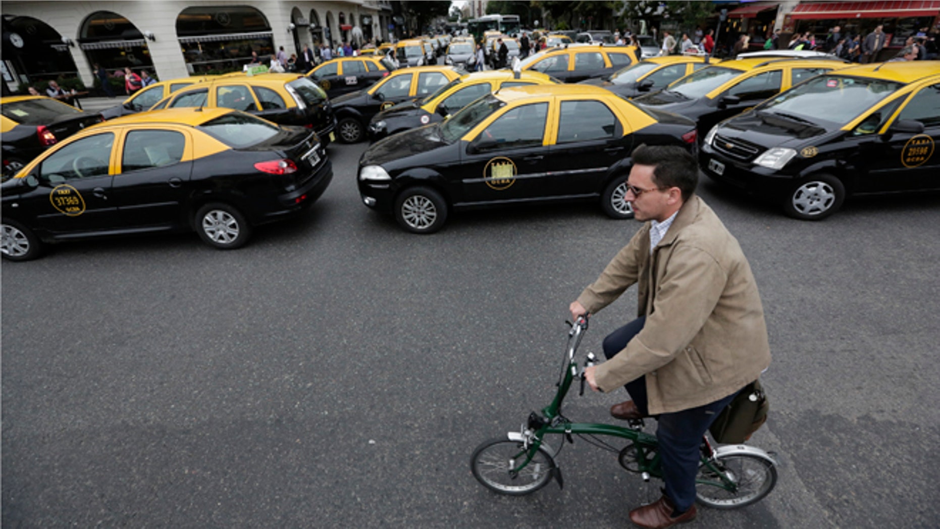 A man rides his bicycle past taxis blocking an avenue in Buenos Aires, Argentina, on April 12, 2016.