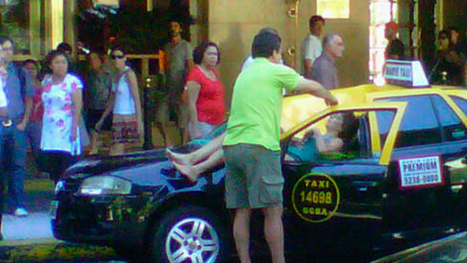 In this cell phone photo provided by Infobae.com received via Twitter from @denisitabaires , a woman lies over a taxi after falling from the 23 floor of a hotel in downtown Buenos Aires, Argentina, Monday, Jan. 24, 2011. The seriously injured woman was taken to a hospital while the taxi driver managed to get out of the car before the impact. (AP Photo/Infobae.com,@Denisitabaires) NO SALES - MANDATORY CREDIT