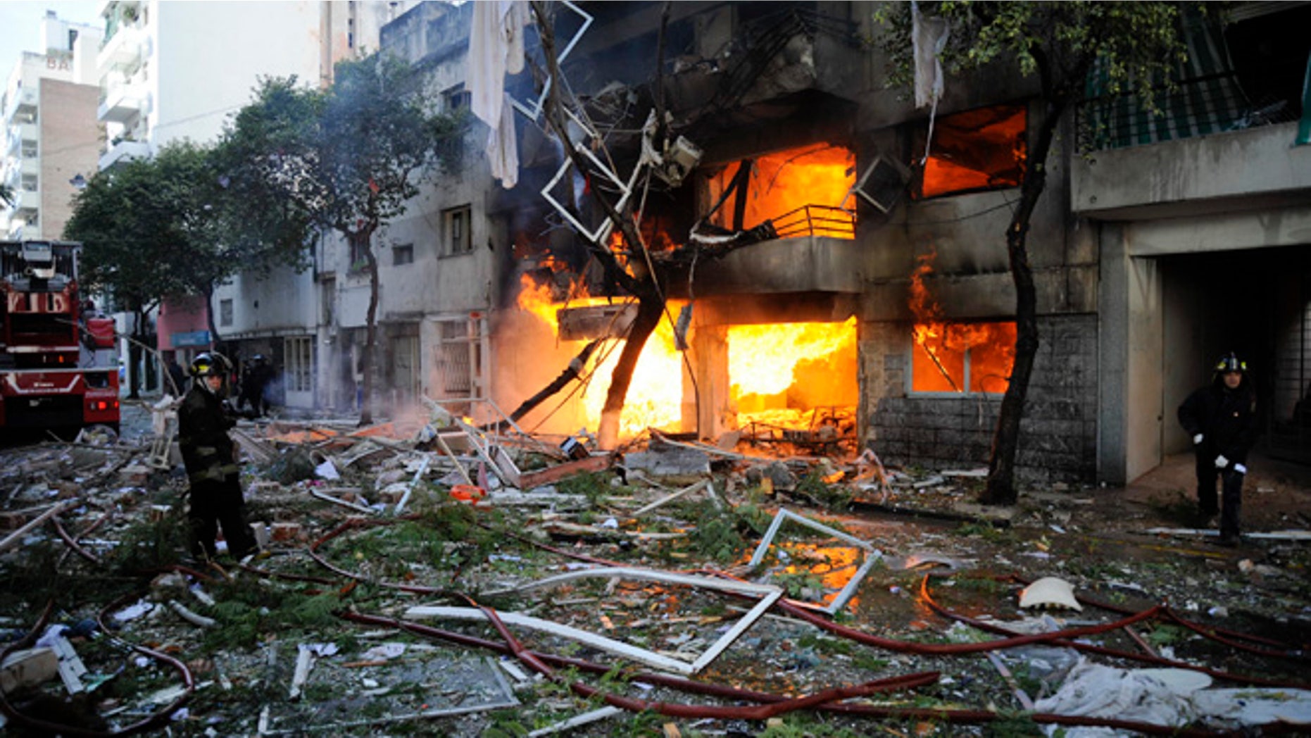 Aug. 6, 2013: Firemen stand in debris caused by a gas explosion that has severely damaged a multi-story apartment building in Rosario, Argentina.