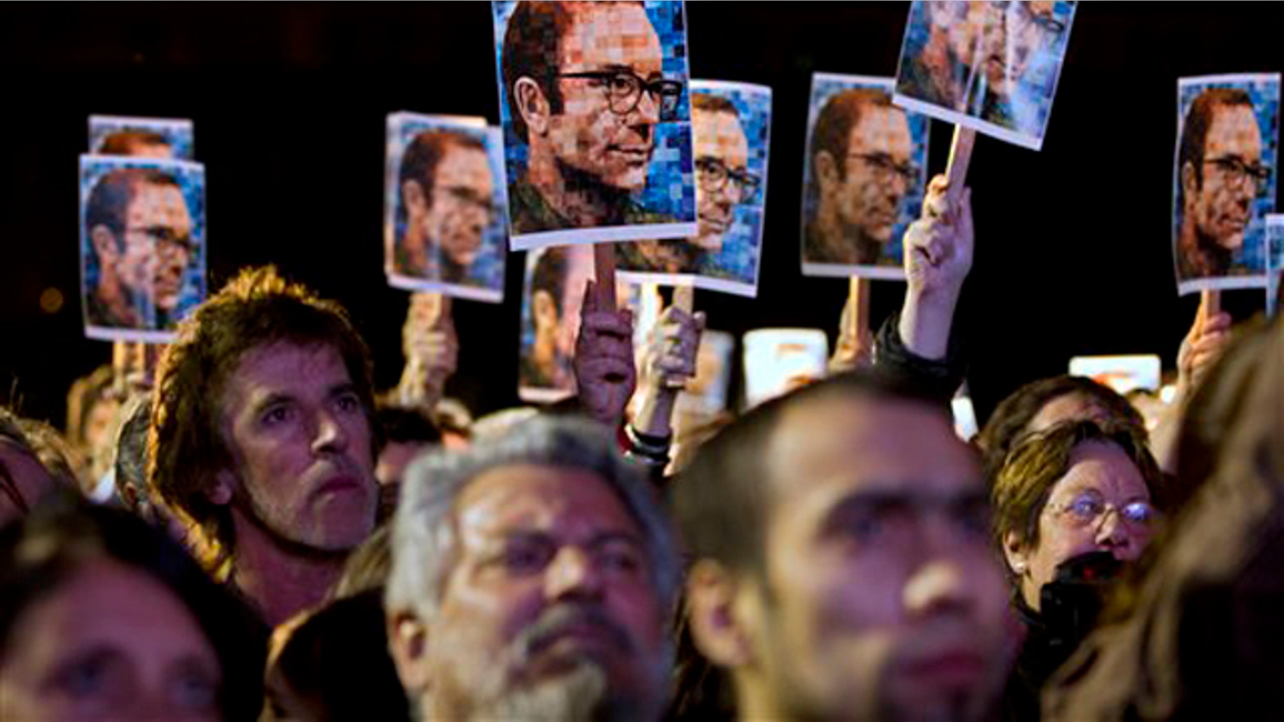 Oct. 26, 2011: People hold up photos of Argentine missing journalist and writer Rodolfo Walsh as they wait for the verdict of a trial against former military and police officials in Buenos Aires, Argentina on Wednesday.