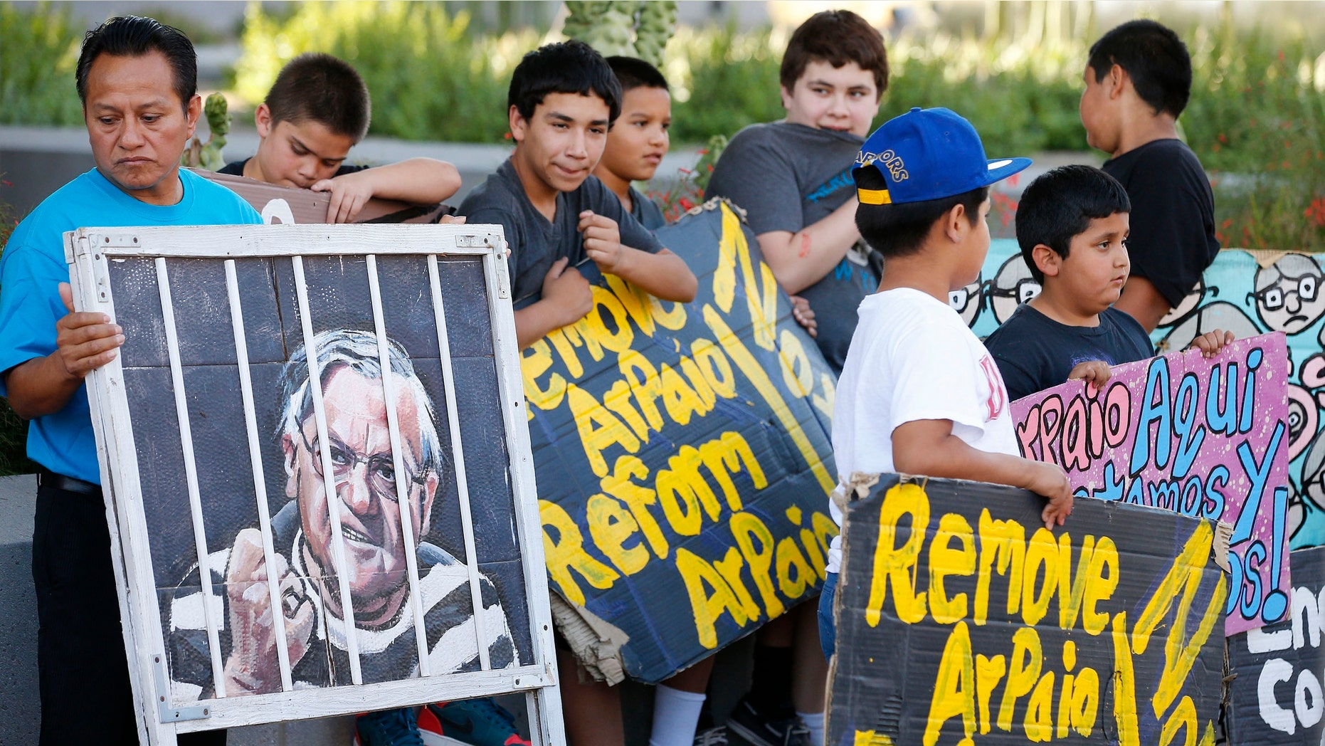 Protesters rally in front of Maricopa County Sheriff's Office Headquarters Wednesday, May 25, 2016, in Phoenix. Arizona taxpayers could be paying out to compensate hundreds of Latinos who were illegally detained when Sheriff Joe Arpaio rounded them up in past immigration patrols. (AP Photo/Ross D. Franklin)