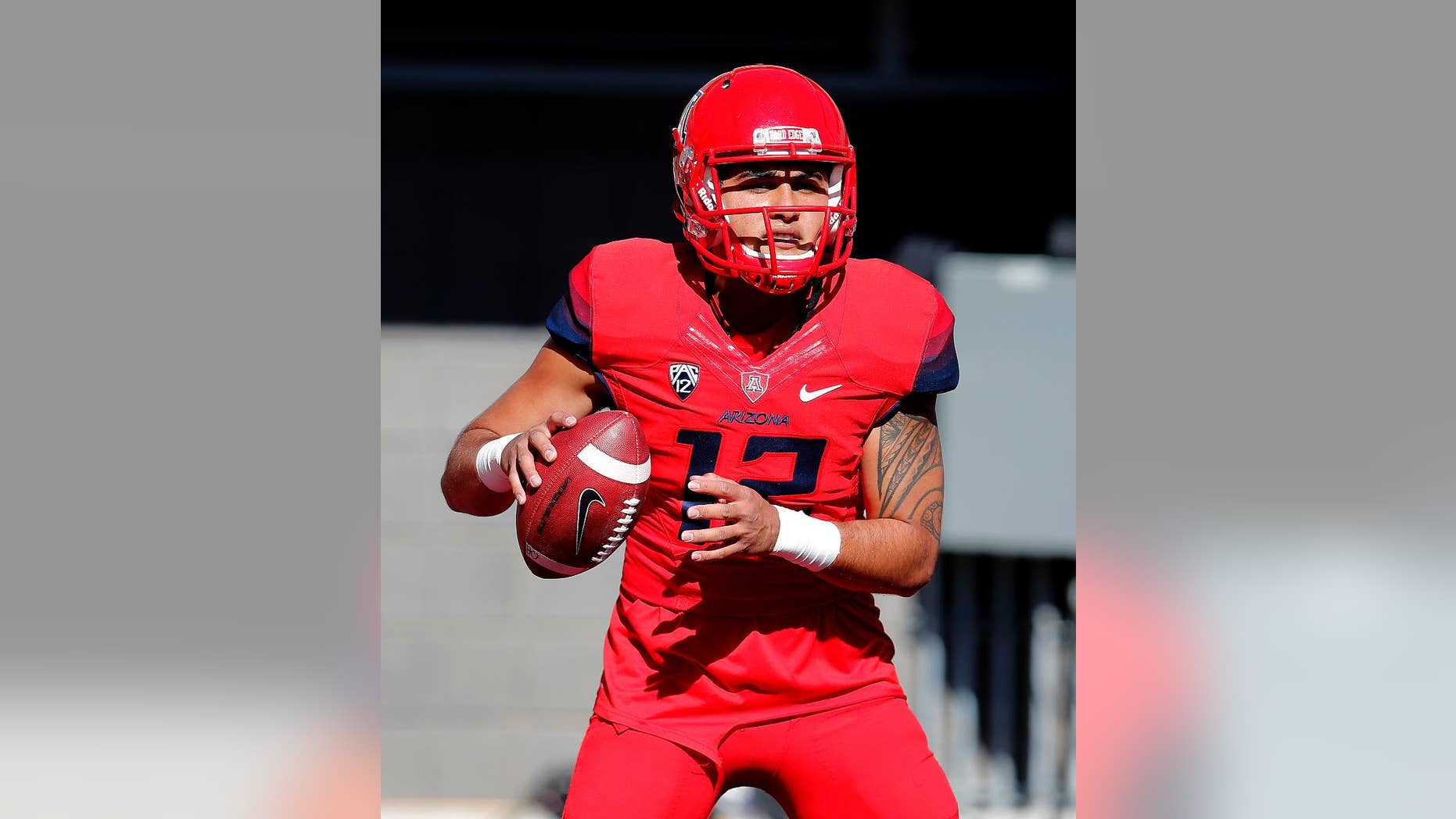 Arizona quarterback Anu Solomon (12) warms up before an NCAA college football game against Arizona State, Friday, Nov. 28, 2014, in Tucson, Ariz. (AP Photo/Rick Scuteri)