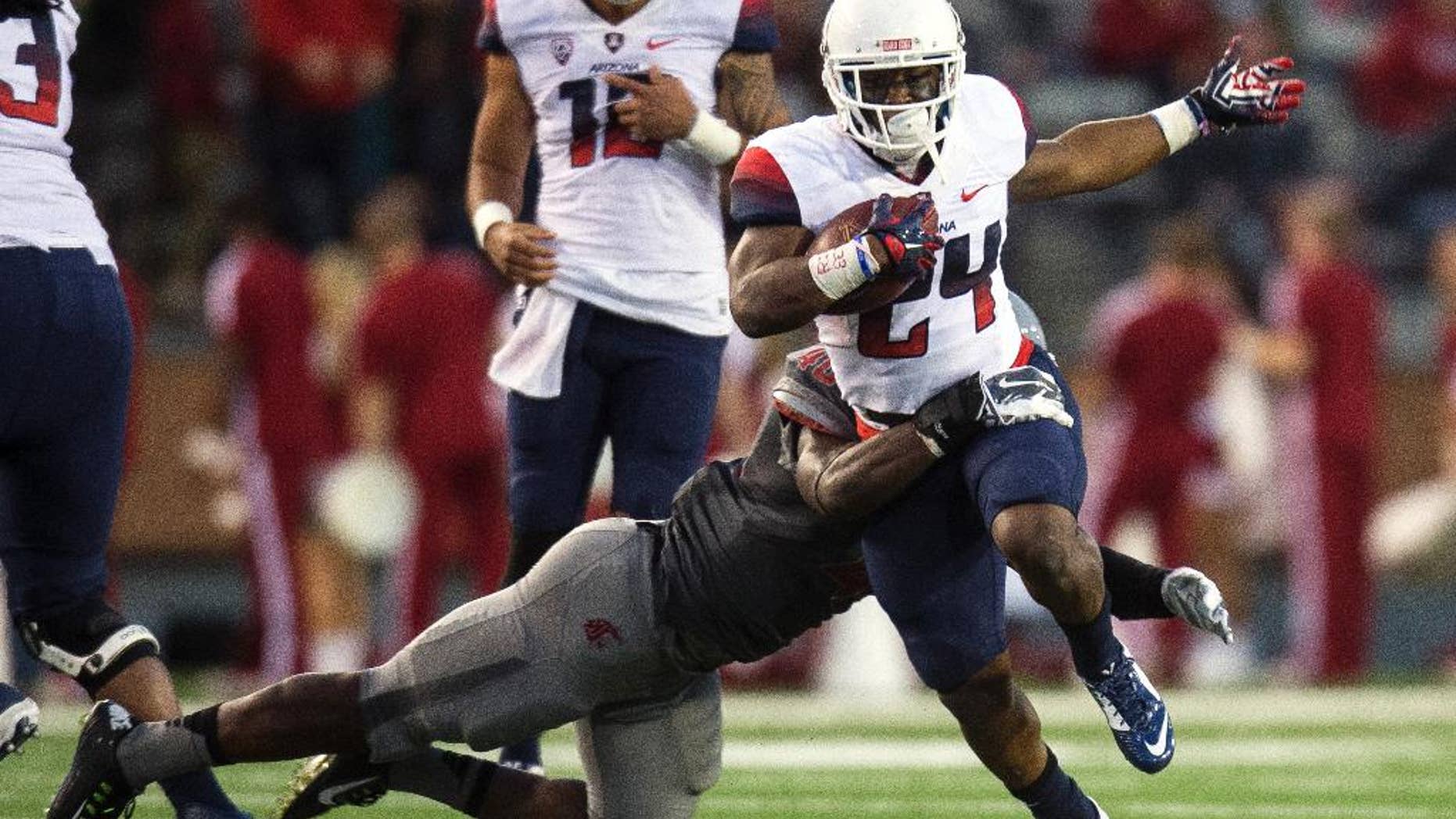 Arizona wide receiver Terris Jones-Grigsby (24) is tackled by Washington State linebacker Kache Palacio during the third quarter of an NCAA college football game Saturday, Oct. 25, 2014, in Pullman, Wash. Arizona won 59-37. (AP Photo/Dean Hare)