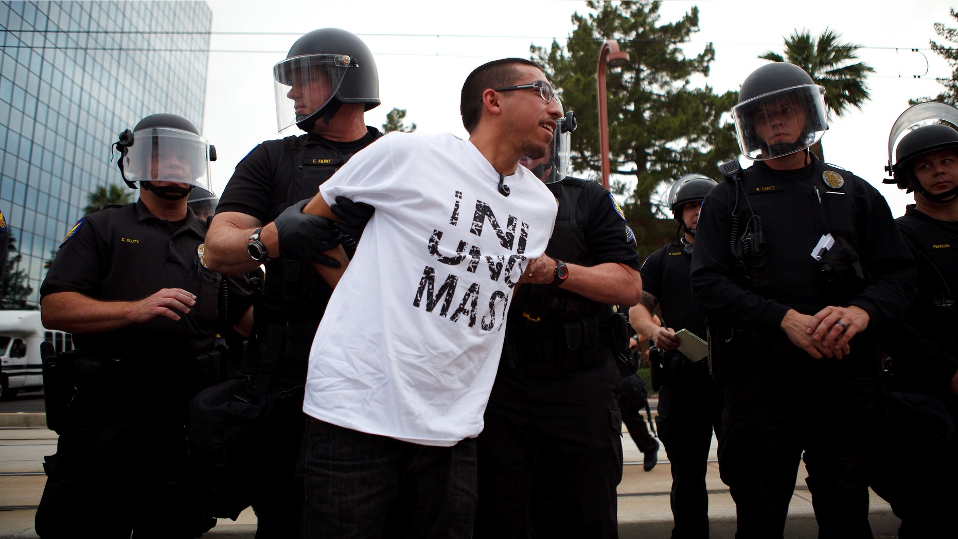 A protester opposed to SB 1070 is taken into custody by police officers April 25, 2012 in Phoenix, Arizona. (Photo by Jonathan Gibby/Getty Images)