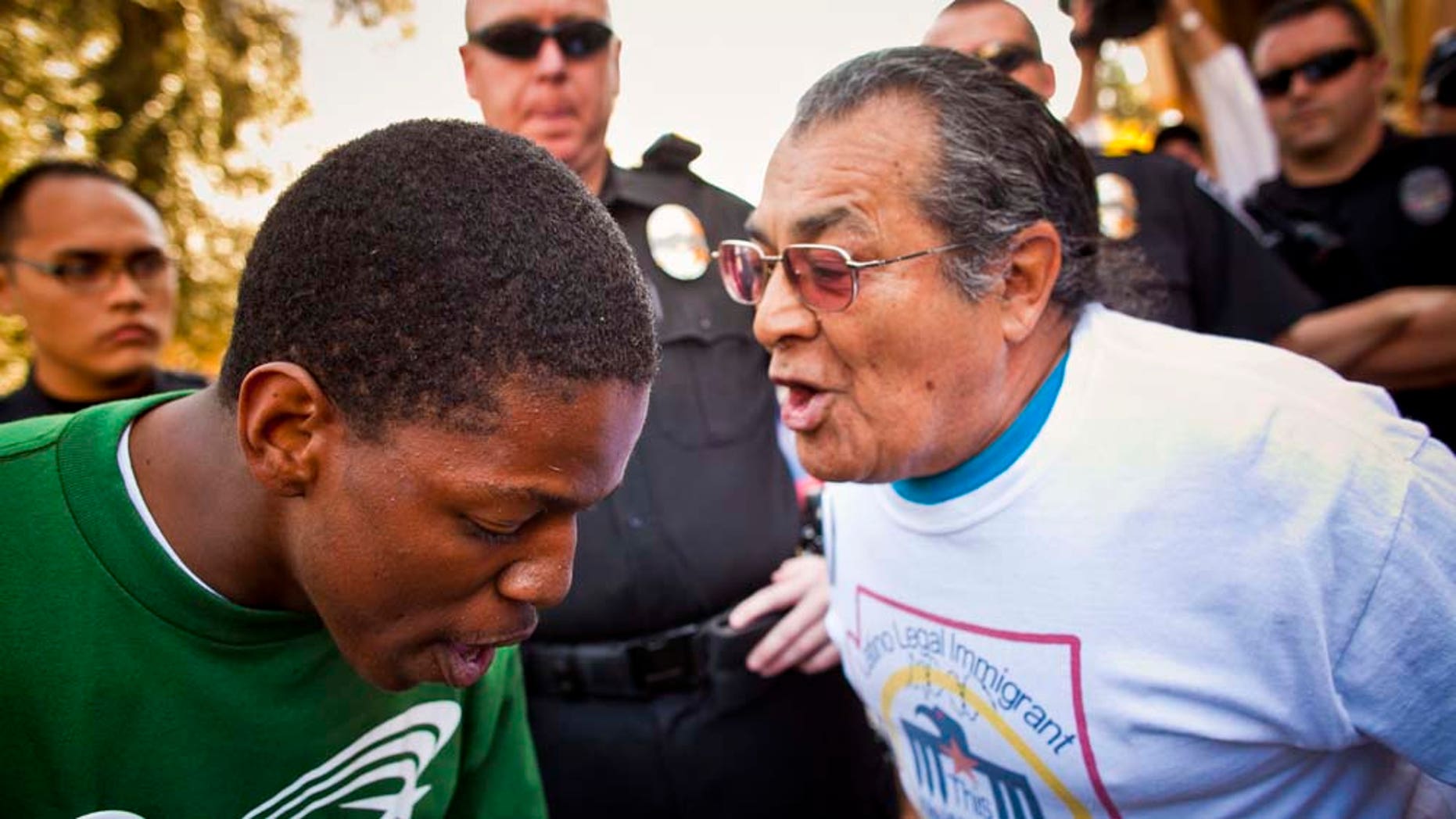 Jarvis Johnson, leftt, , a supporter of immigrants' rights and Arthur Olivas, right, a supporter of Sen Russell Pearce's anti-immigrant bills, debate at the State Capitol in Phoenix Tuesday, Feb. 22, 2011. A sweeping bill that targets illegal immigrants in public housing, public benefits and the workplace drew vocal opposition Tuesday from Democrats. The Senate Appropriations Committee was considering the 29-page bill Tuesday, a day after it was introduced by Republican Senate President Russell Pearce, who authored last year's controversial SB 1070. That law touched off a nationwide debate on whether states can enforce federal immigration laws. Democrats don't have the votes to block the measure, but the topic brought out supporters on both sides and security at the Senate was heightened, with about a dozen uniformed police officers deployed in and around the building. (AP Photo/The Arizona Republic, Jack Kurtz)