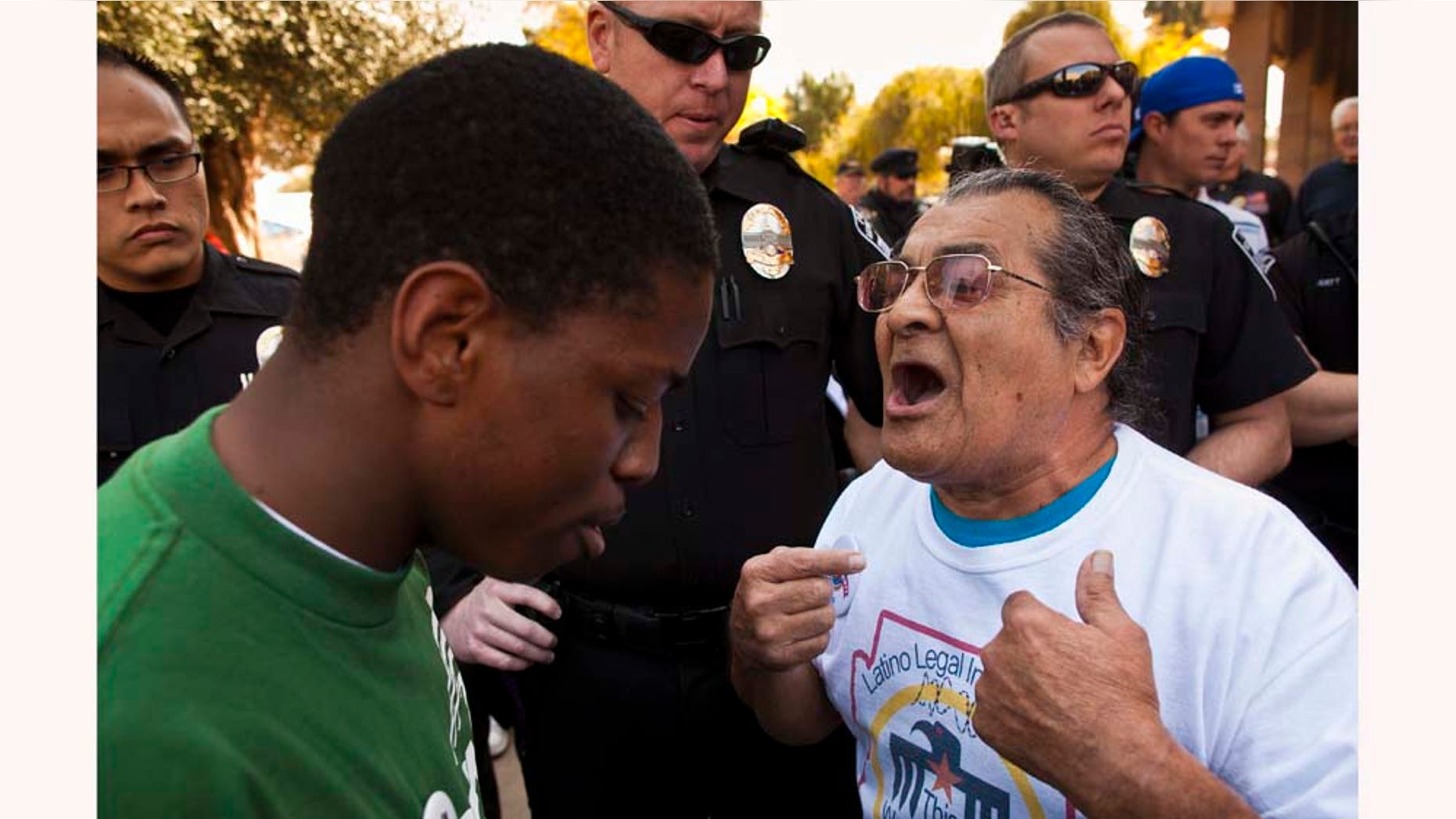 Jarvis Johnson, leftt, , a supporter of immigrants' rights and Arthur Olivas, right, a supporter of Sen Russell Pearce's anti-immigrant bills, debate at the State Capitol in Phoenix Tuesday, Feb. 22, 2011. A sweeping bill that targets illegal immigrants in public housing, public benefits and the workplace drew vocal opposition Tuesday from Democrats. The Senate Appropriations Committee was considering the 29-page bill Tuesday, a day after it was introduced by Republican Senate President Russell Pearce, who authored last year's controversial SB 1070. That law touched off a nationwide debate on whether states can enforce federal immigration laws. Democrats don't have the votes to block the measure, but the topic brought out supporters on both sides and security at the Senate was heightened, with about a dozen uniformed police officers deployed in and around the building. (AP Photo/The Arizona Republic, Jack Kurtz)