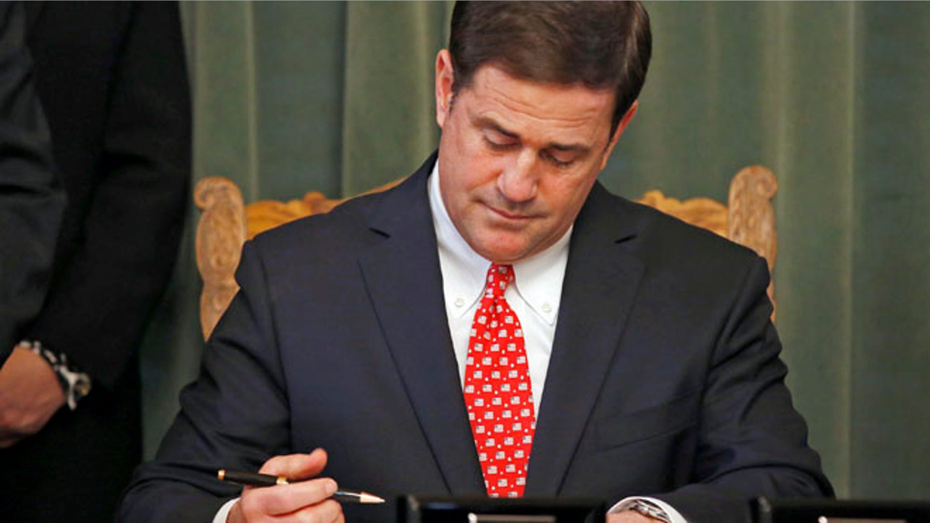 Feb. 24, 2015: Arizona Republican Gov. Doug Ducey signs the American Civics Act into law during a bill signing ceremony at the Capitol in Phoenix.